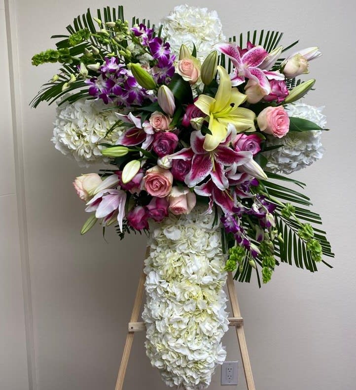 Large floral standing spray with lilies, roses, orchids, and white hydrangeas