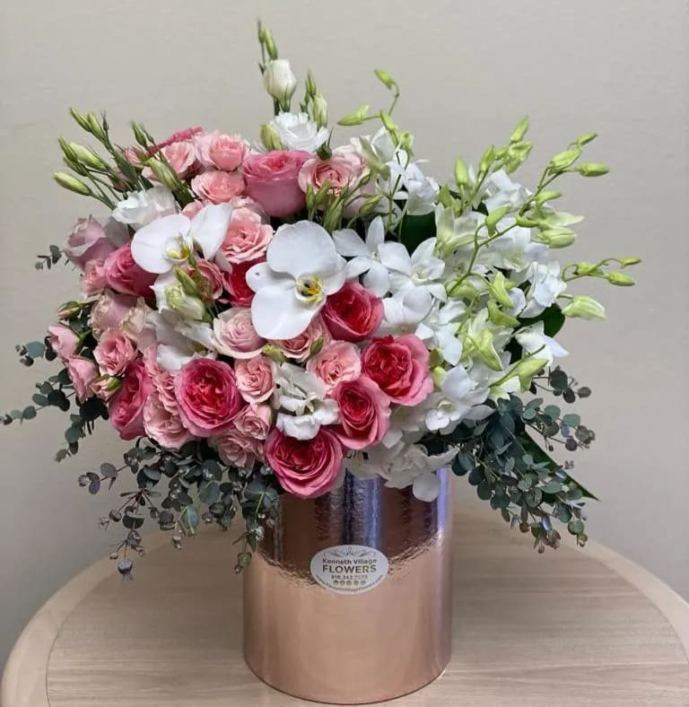 Pink and white floral arrangement in a metallic vase