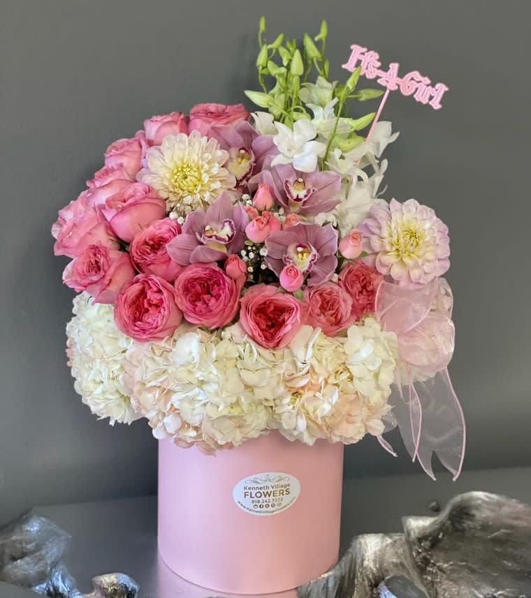 Pink and white bouquet in a pink hat box with a ribbon