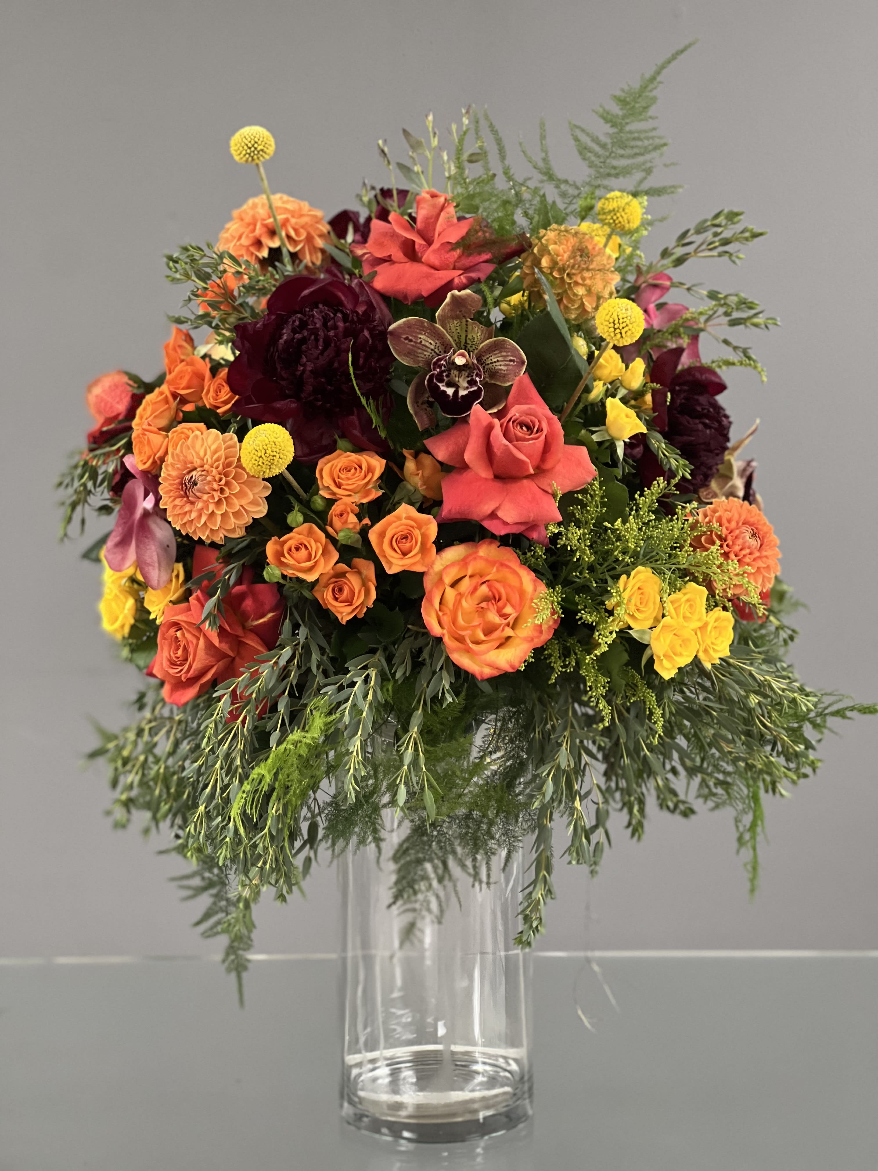 Mixed orange, pink, and yellow bouquet in a clear glass vase