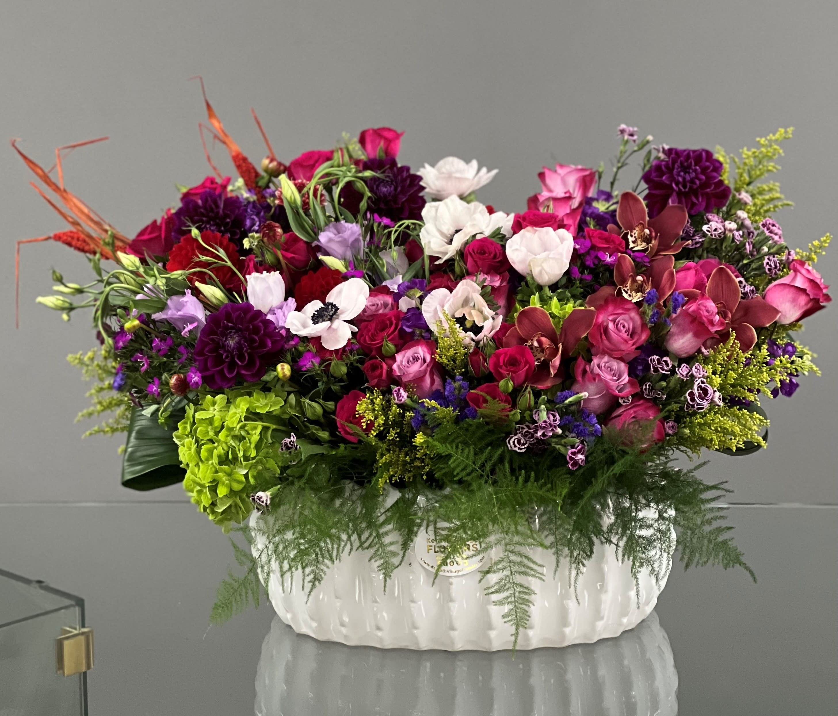 Large mixed floral arrangement in a white ceramic container