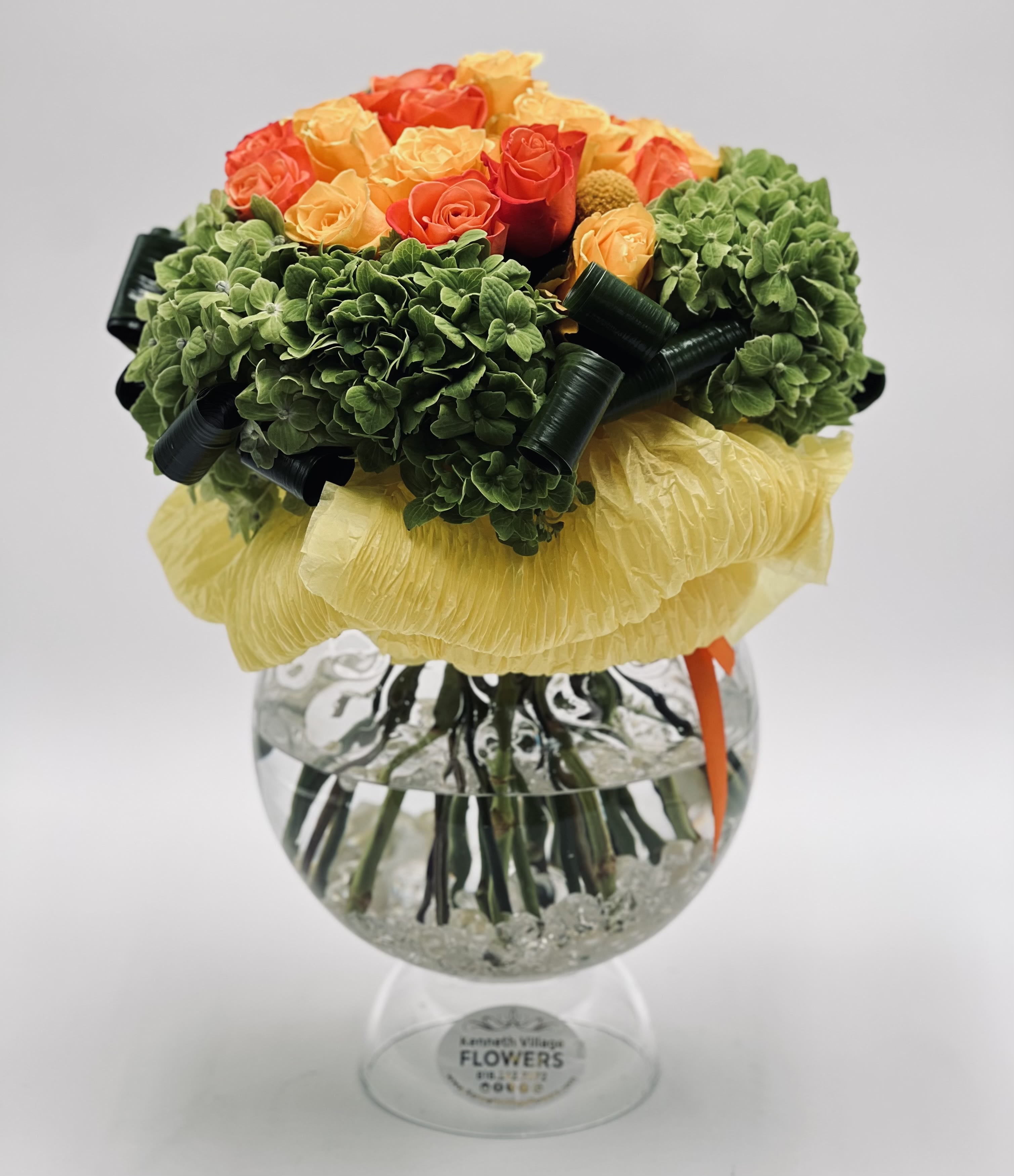 Bouquet of orange and yellow roses in a clear glass vase