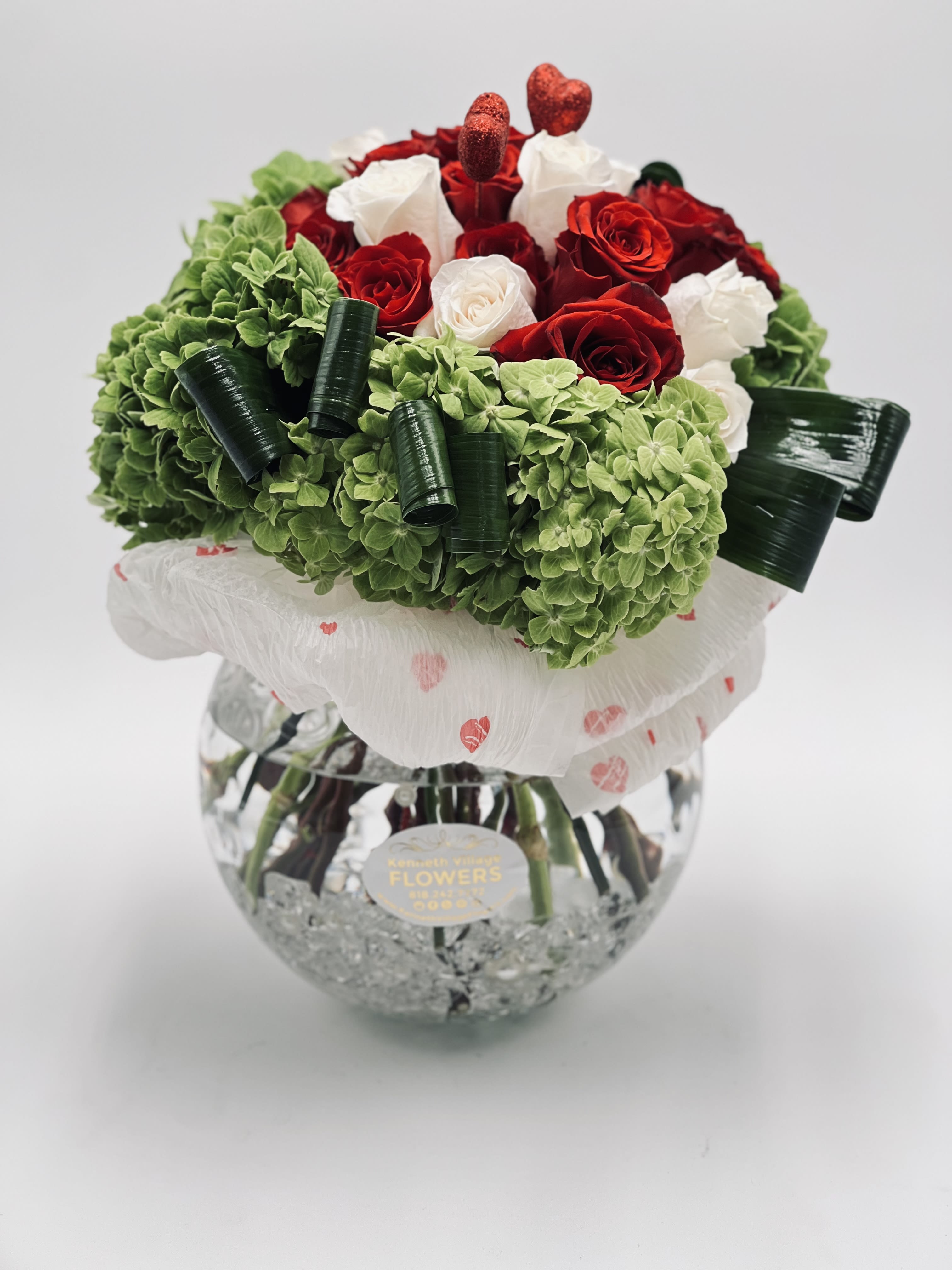Bouquet of red and white roses with green hydrangeas in a glass vase