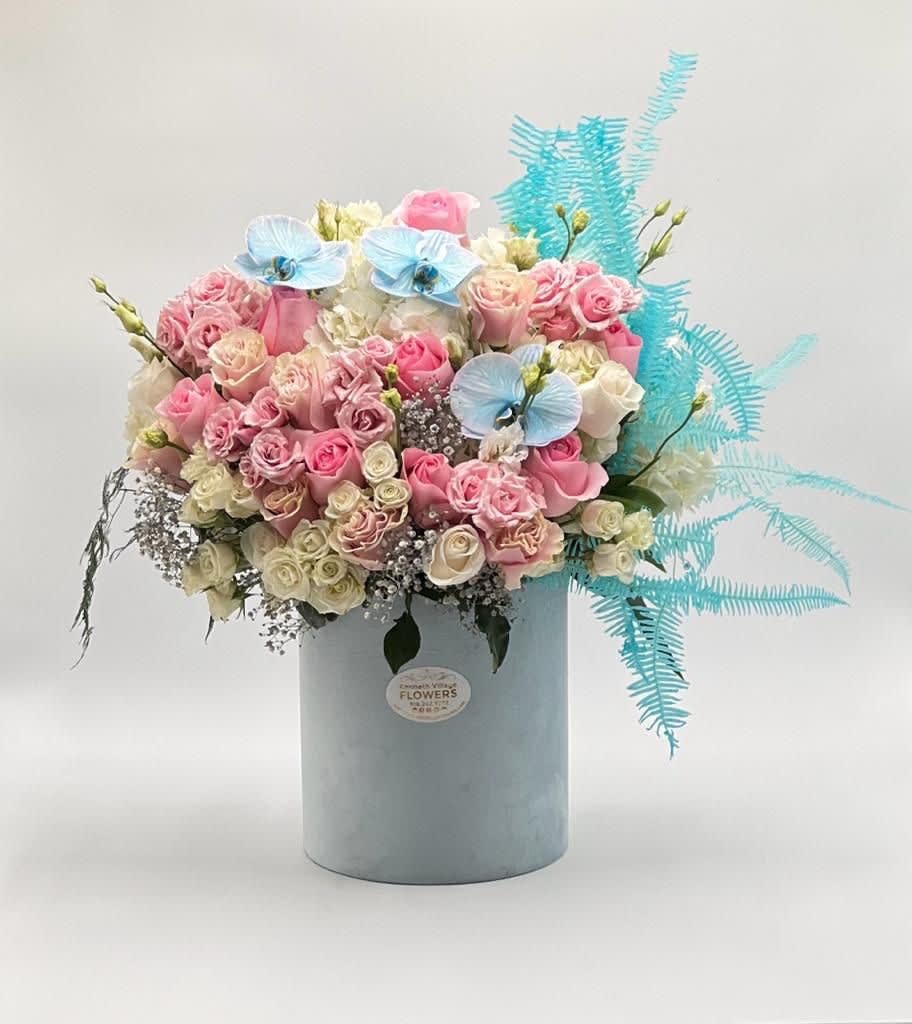 Pink and white rose bouquet in a pale blue box with blue accents