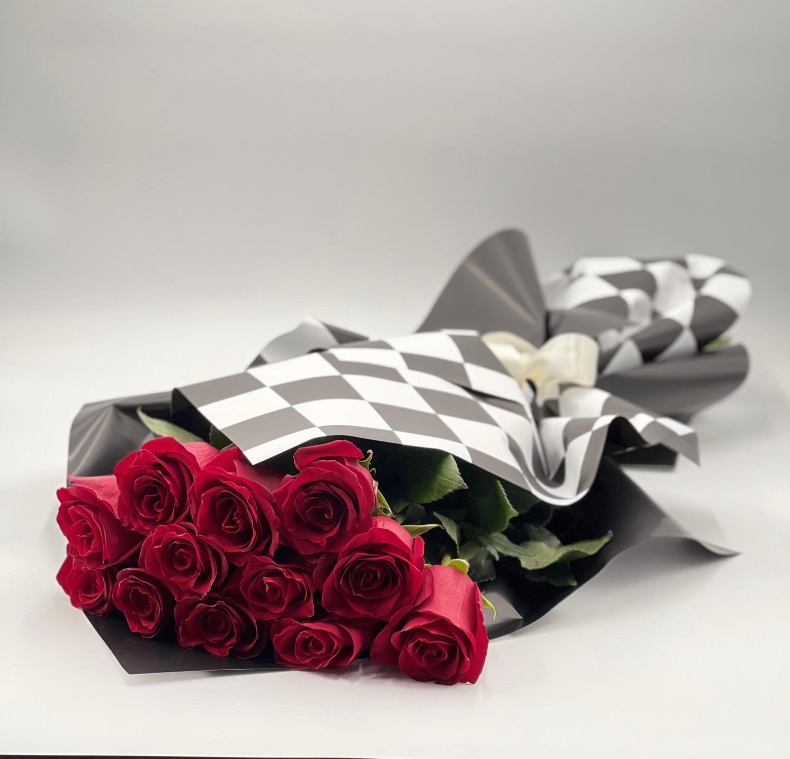 Bouquet of red roses wrapped in black and white paper