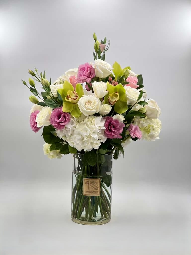Bouquet of white, pink, and green flowers in a clear glass vase