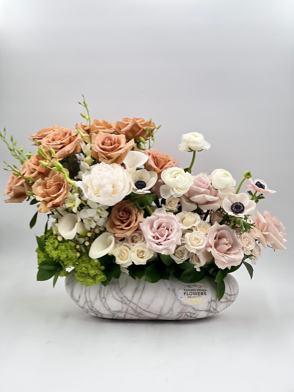 Arrangement of blush and white roses in a marble-patterned vase