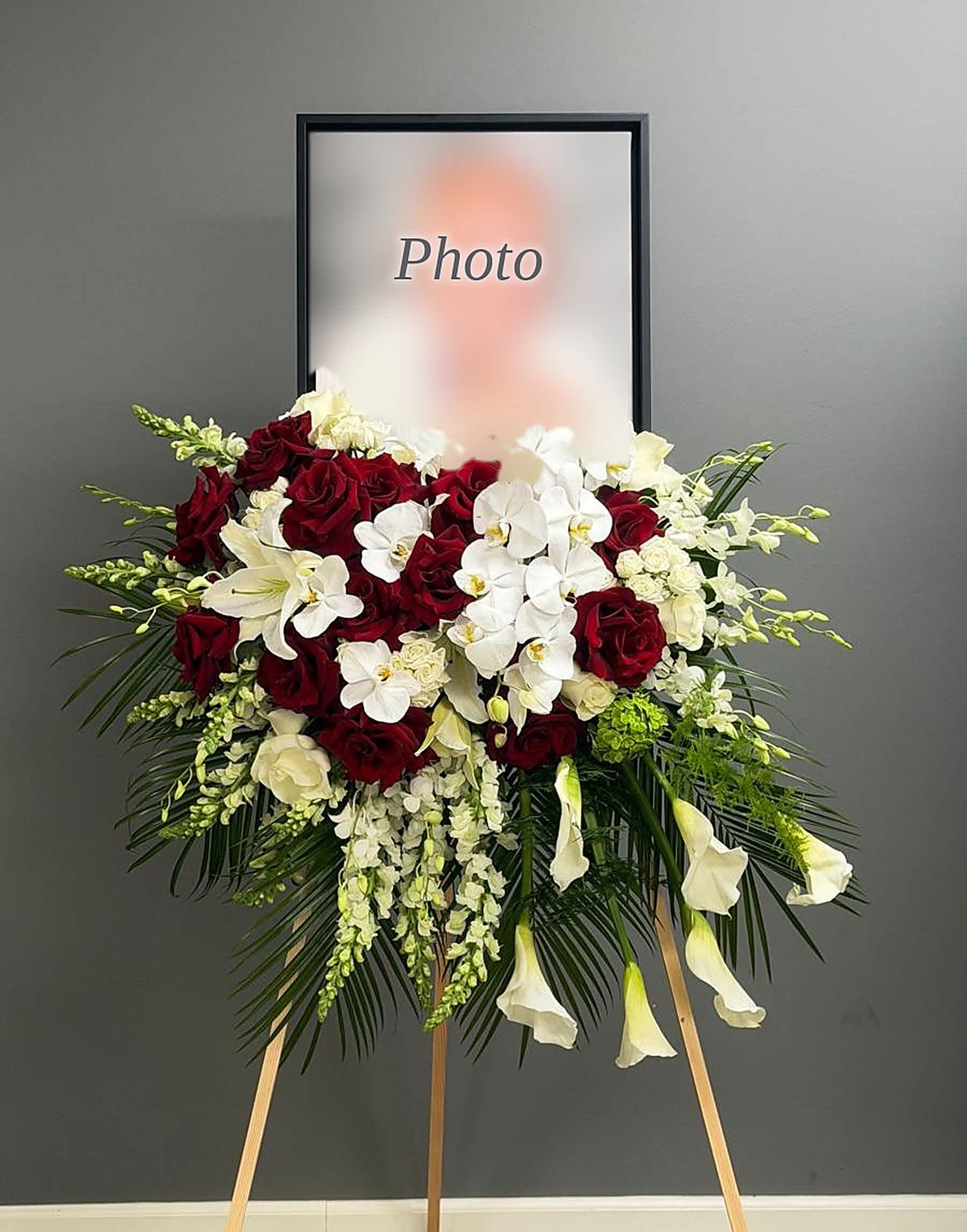 Standing floral spray with red roses, white orchids, and white calla lilies