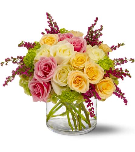 Pink and yellow roses arranged in a clear glass vase