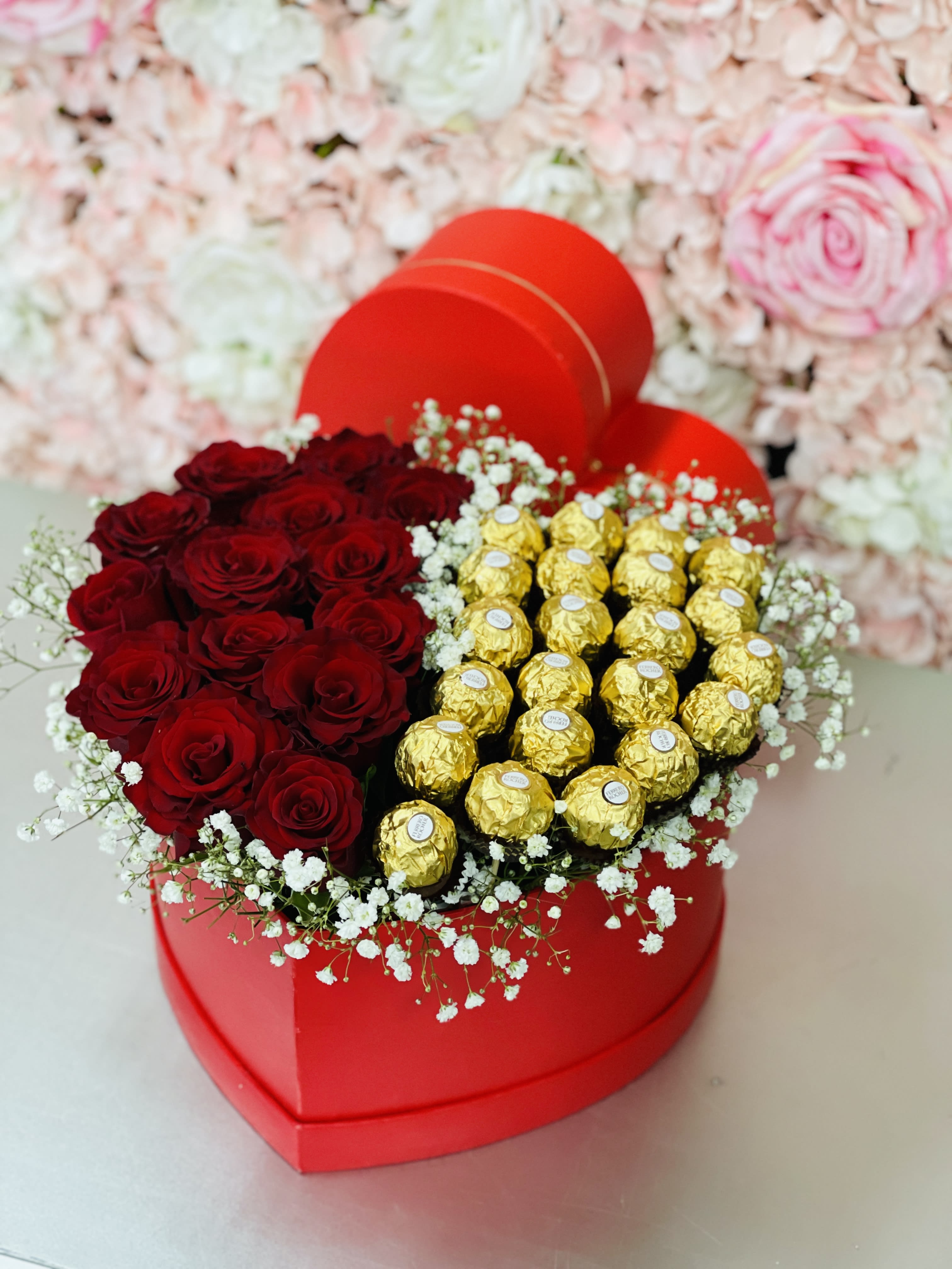Heart-shaped box with red roses and gold-wrapped chocolates