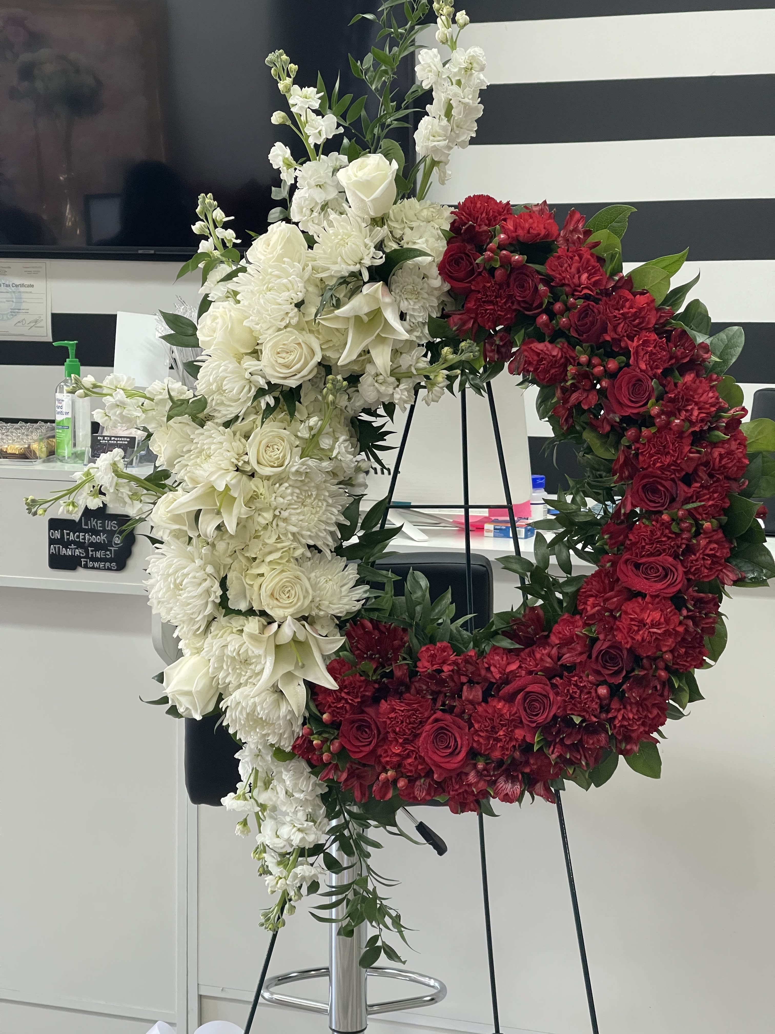 Large red and white floral wreath on a stand