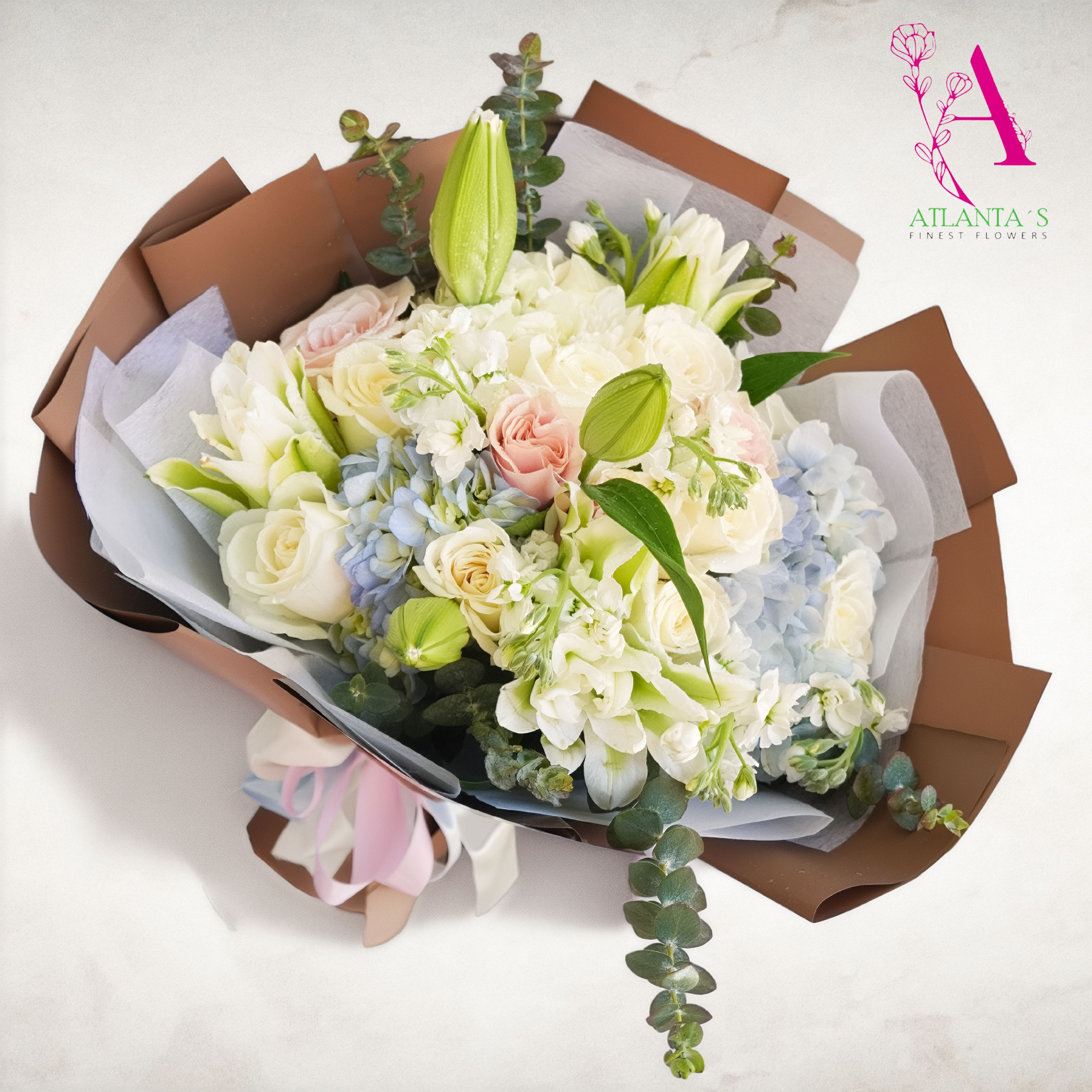 Blush &amp; Blue Dreams Bouquet - This dreamy bouquet features white blooms, blush roses, blue hydrangeas, and fresh lilies wrapped in neutral tones paper — Perfect for celebrating life’s sweetest moments. A beautiful choice for birthdays, anniversaries, baby showers, or simply “just because.”  Made by Atlanta’s Finest Flowers