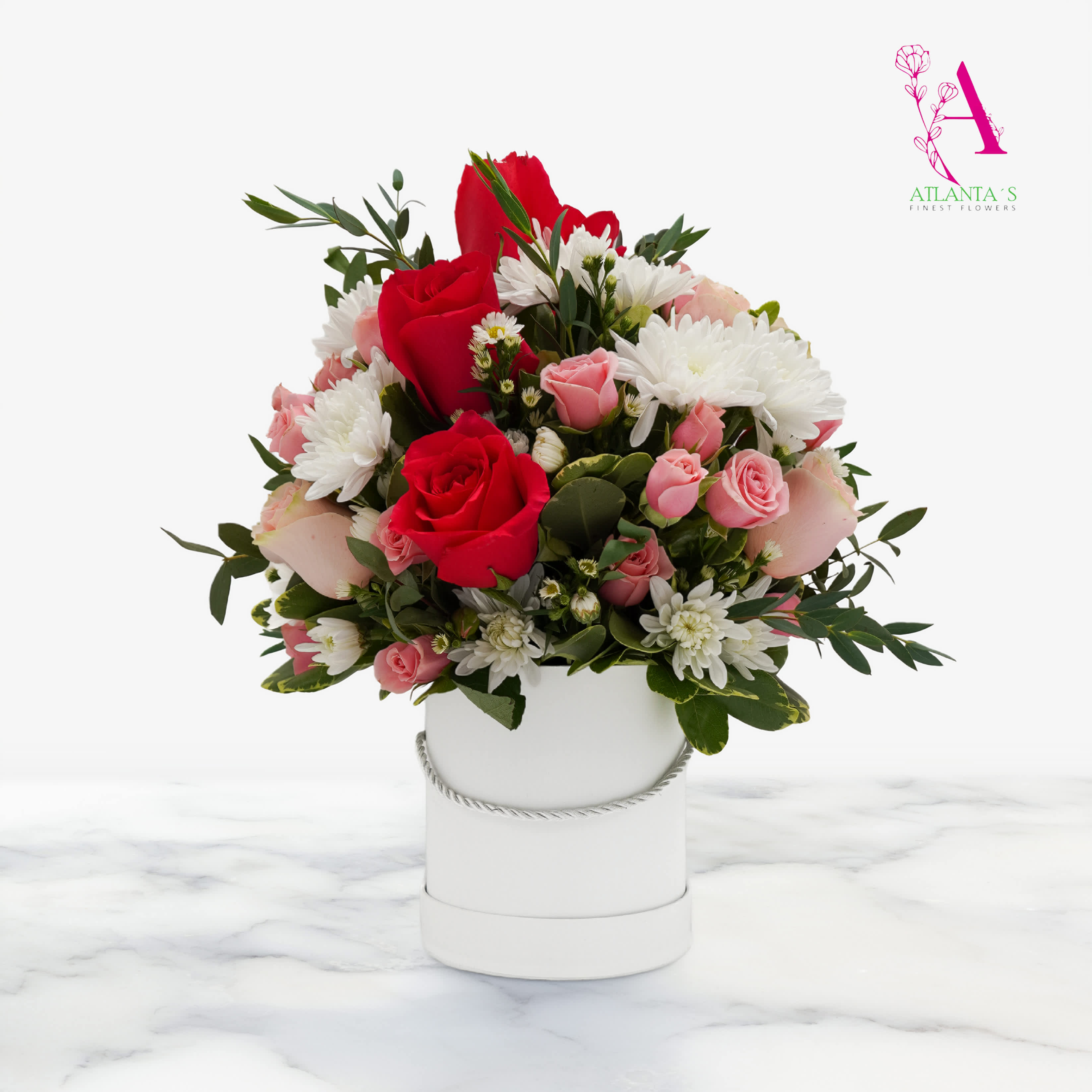 Bouquet of red and pink roses with white daisies in a white hatbox
