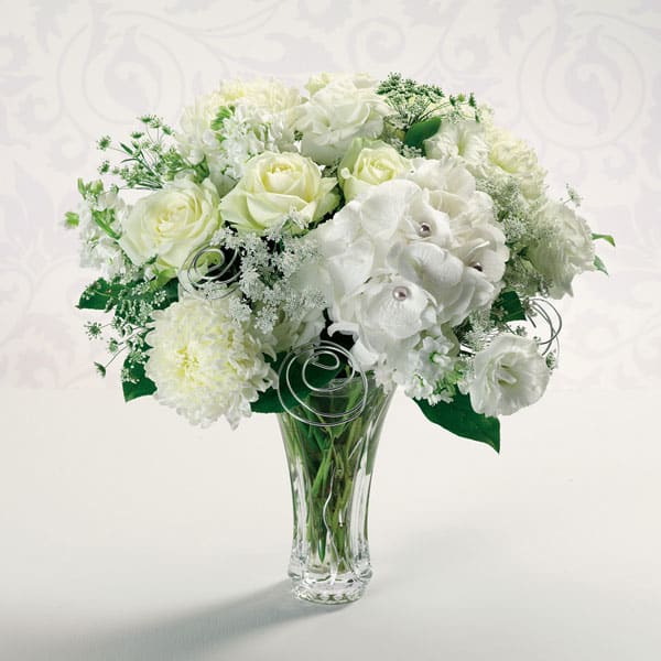 Silver Anniversary - Pearl-studded hydrangea, white roses, Queen Anne's lace and football mums recall all your years together. Show her that "together" is still where you love to be.