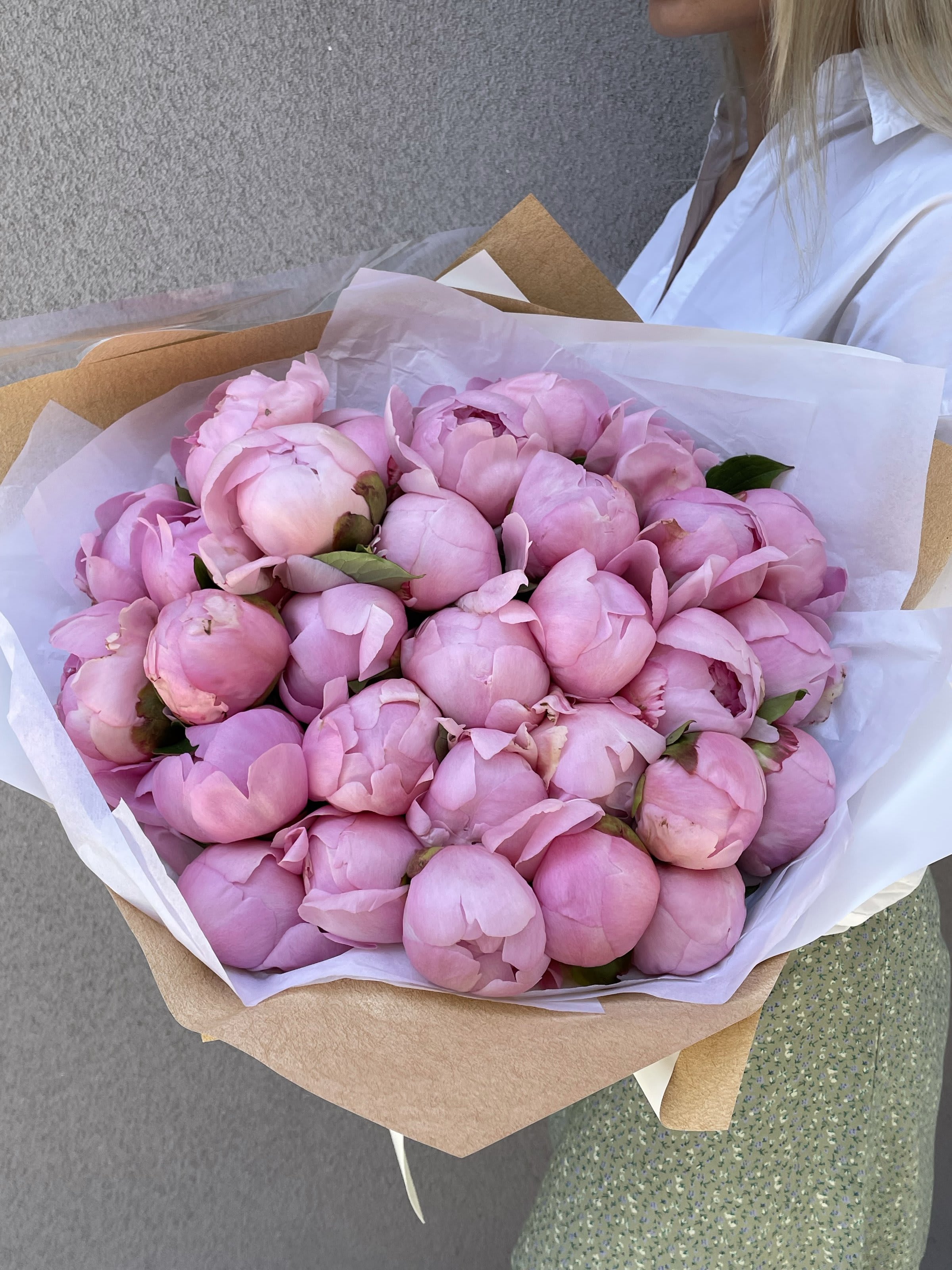 Bouquet of pink peonies wrapped in white and kraft paper