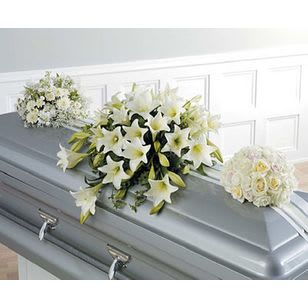 White floral sprays arranged on a gray casket
