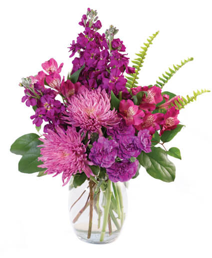 Purple and pink bouquet in a clear glass vase