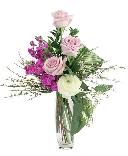 Pink and white roses with purple flowers in a clear glass vase