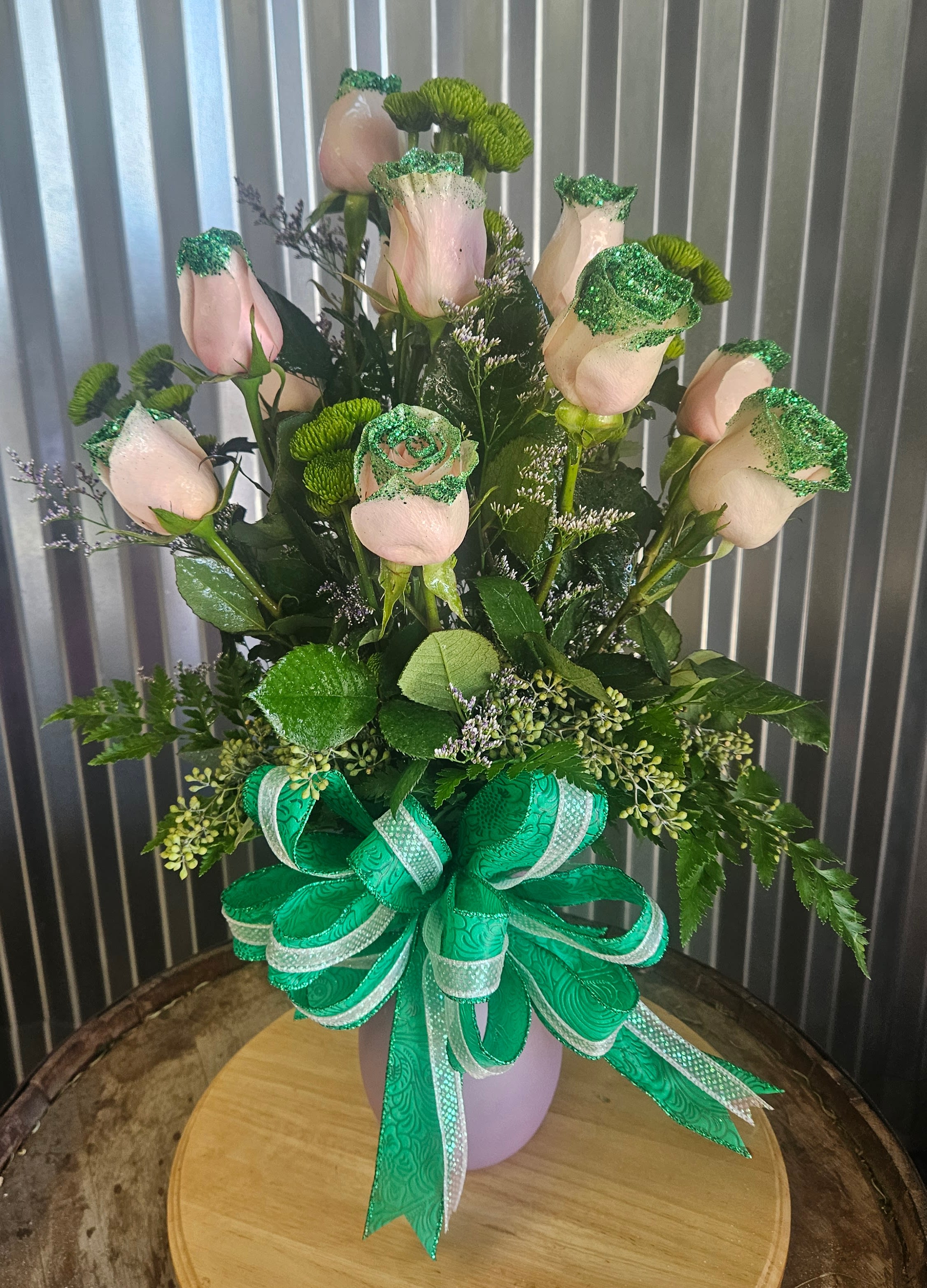 Pink roses in a vase with green ribbon and glittered accents