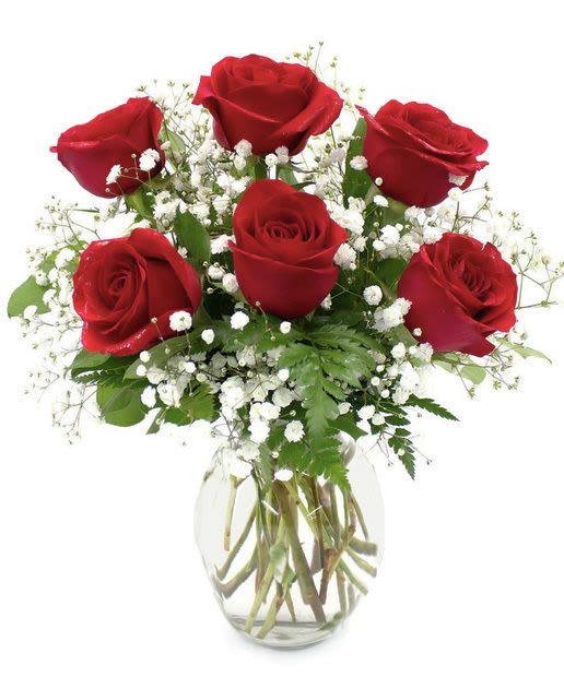 Bouquet of red roses and white baby's breath in a clear glass vase
