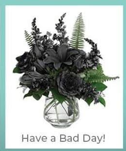 Dark floral arrangement in a clear glass vase with the text 'Have a Bad Day!'