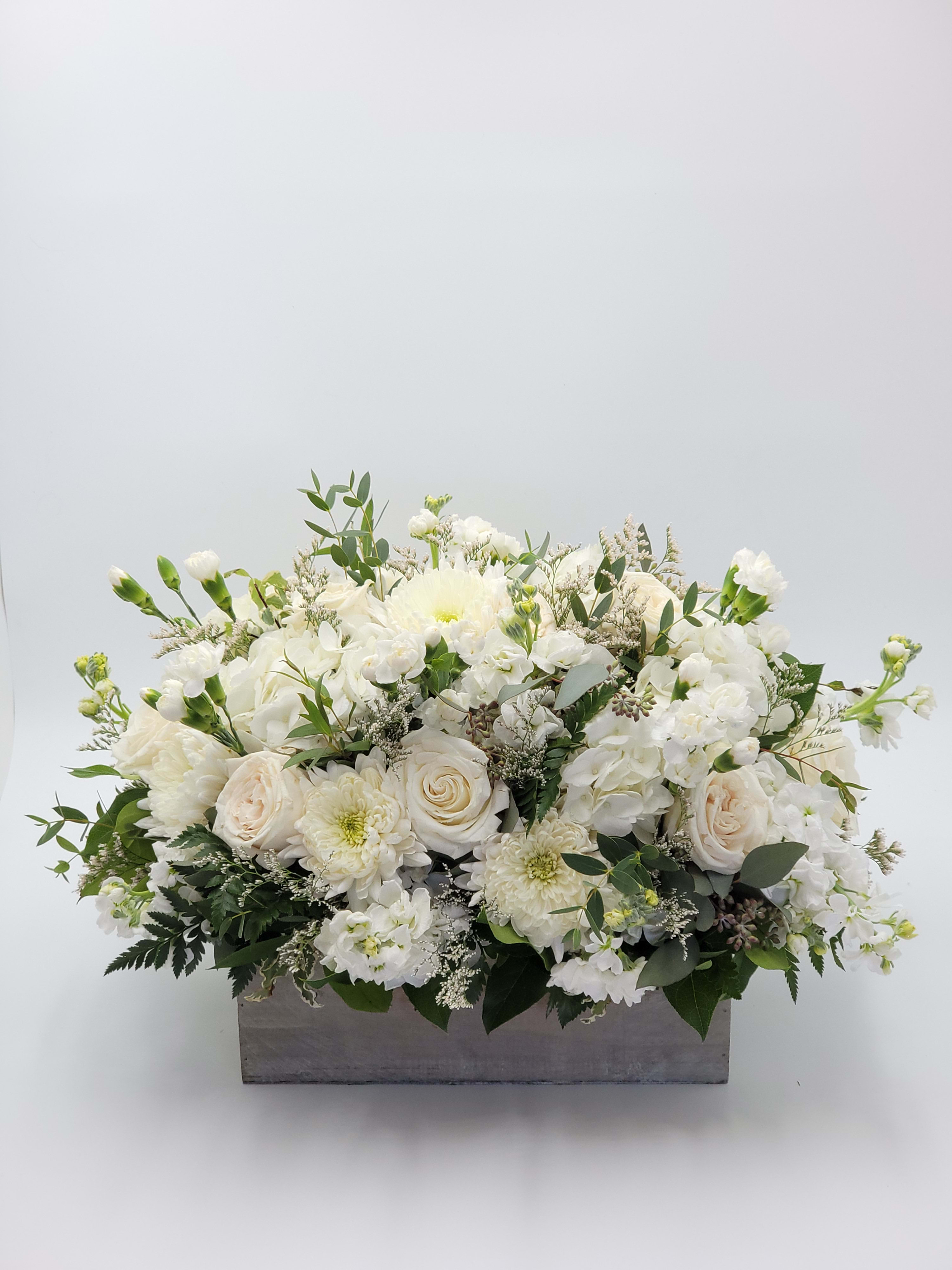 White floral arrangement in a rectangular gray container