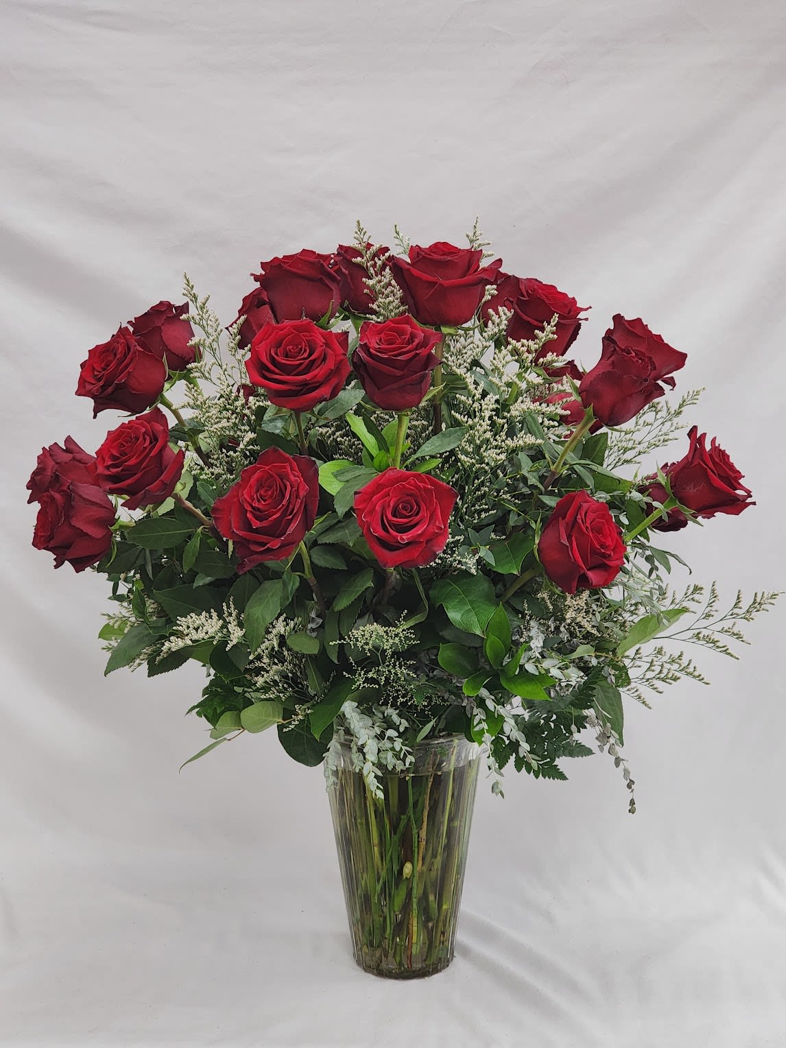 Red roses arranged in a clear glass vase