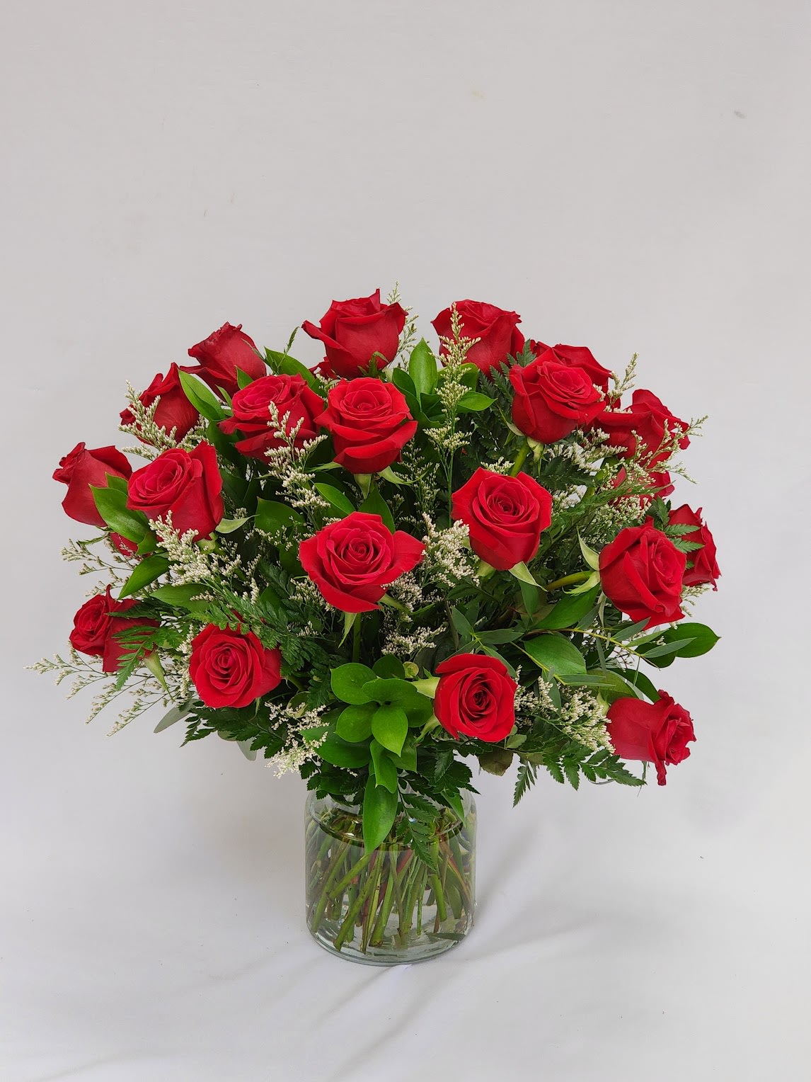 Red roses arranged in a clear glass vase
