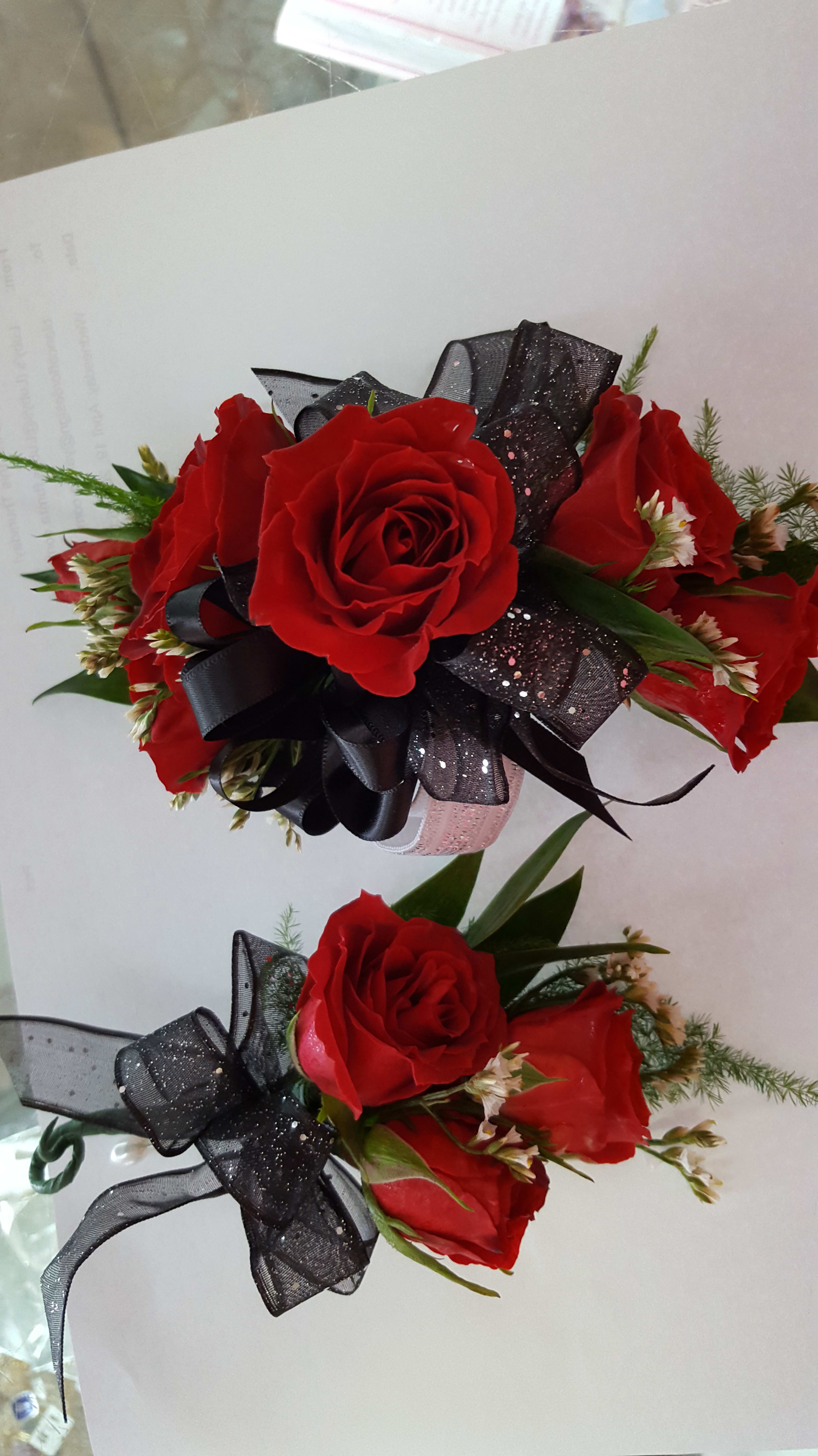 Two red rose bouquets with black ribbon bows