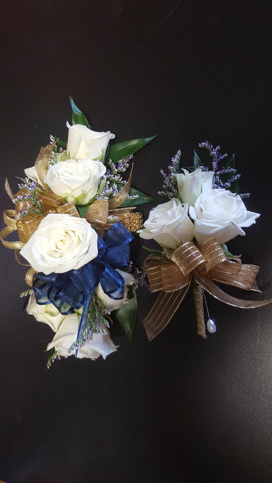 White rose corsages with gold and blue ribbon accents