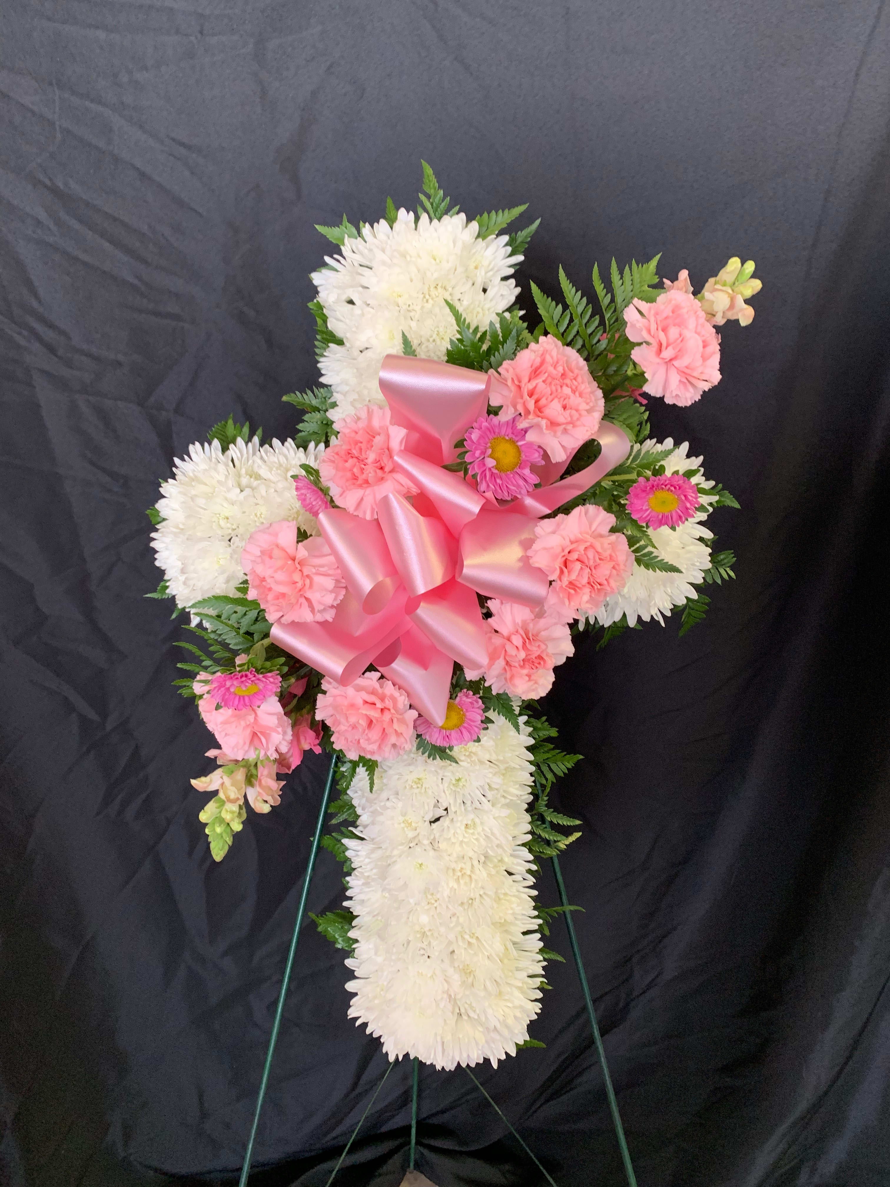 Pink and white floral standing spray with a large pink ribbon