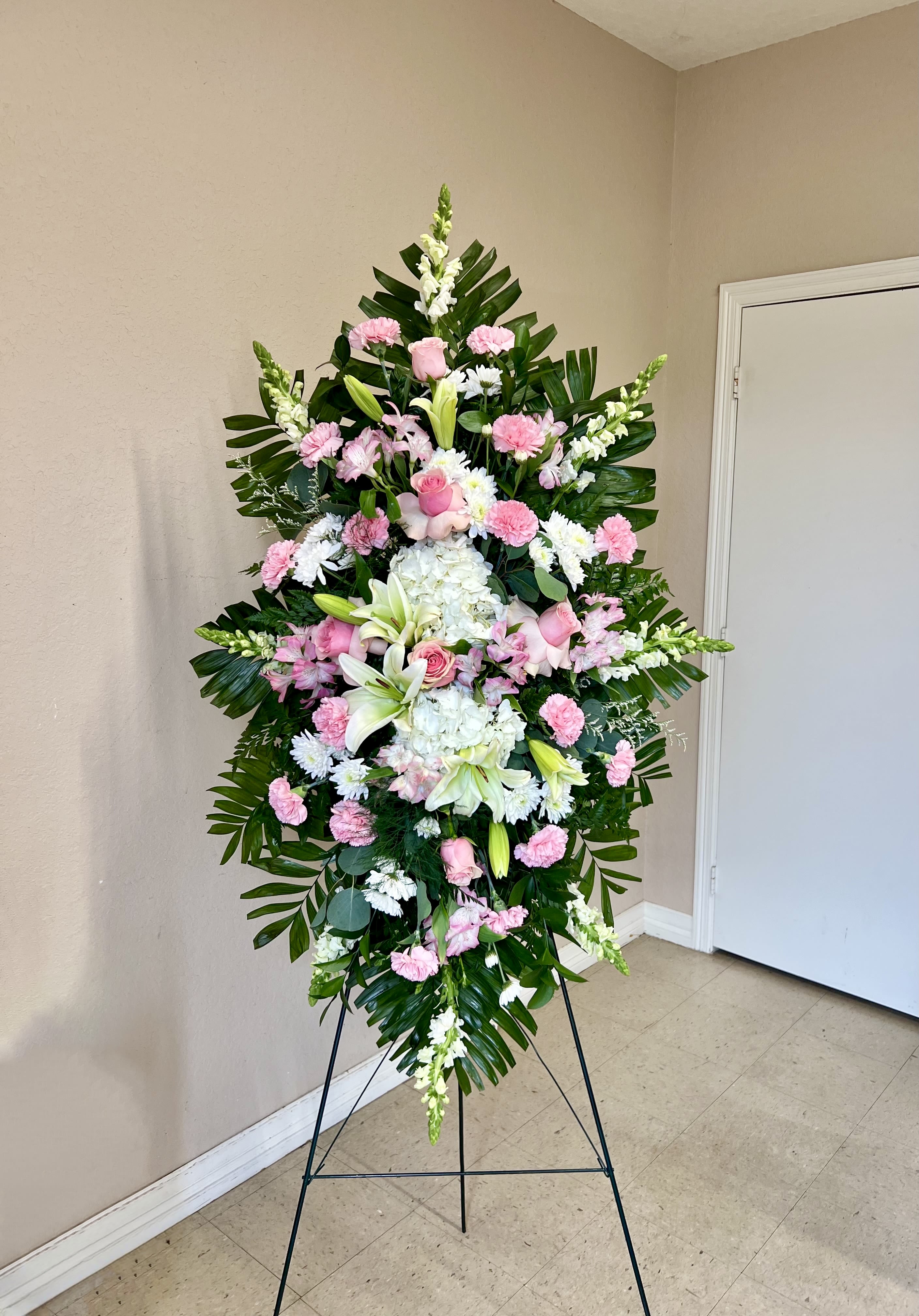 Standing floral spray with pink and white flowers on an easel