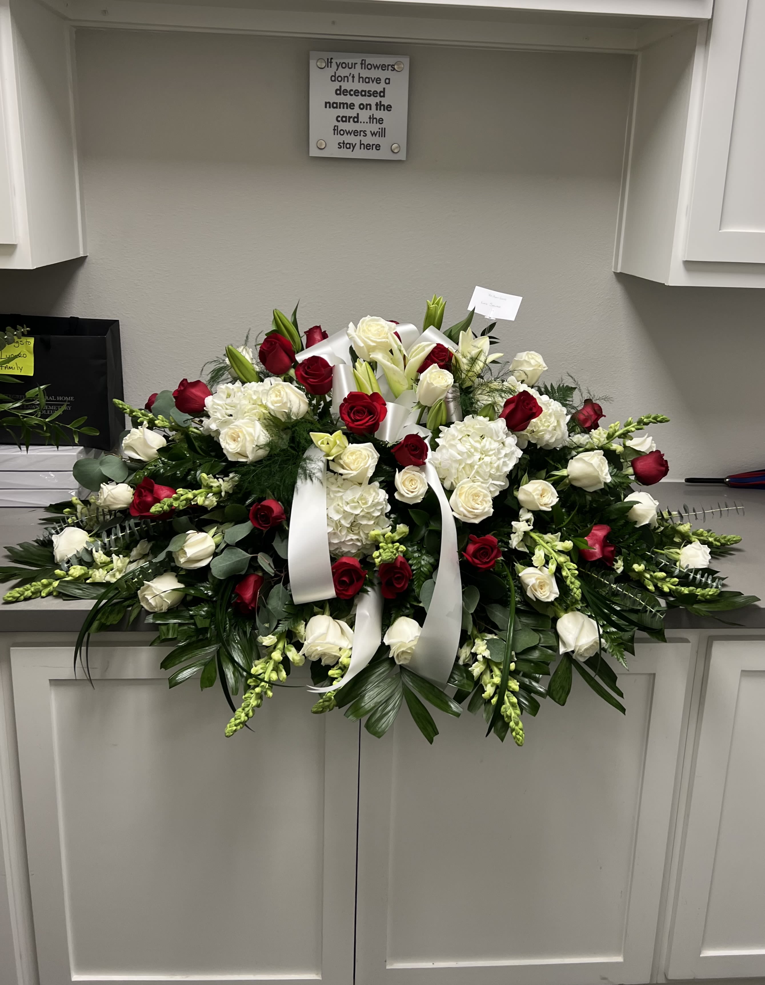 Large red and white funeral spray with roses and lilies