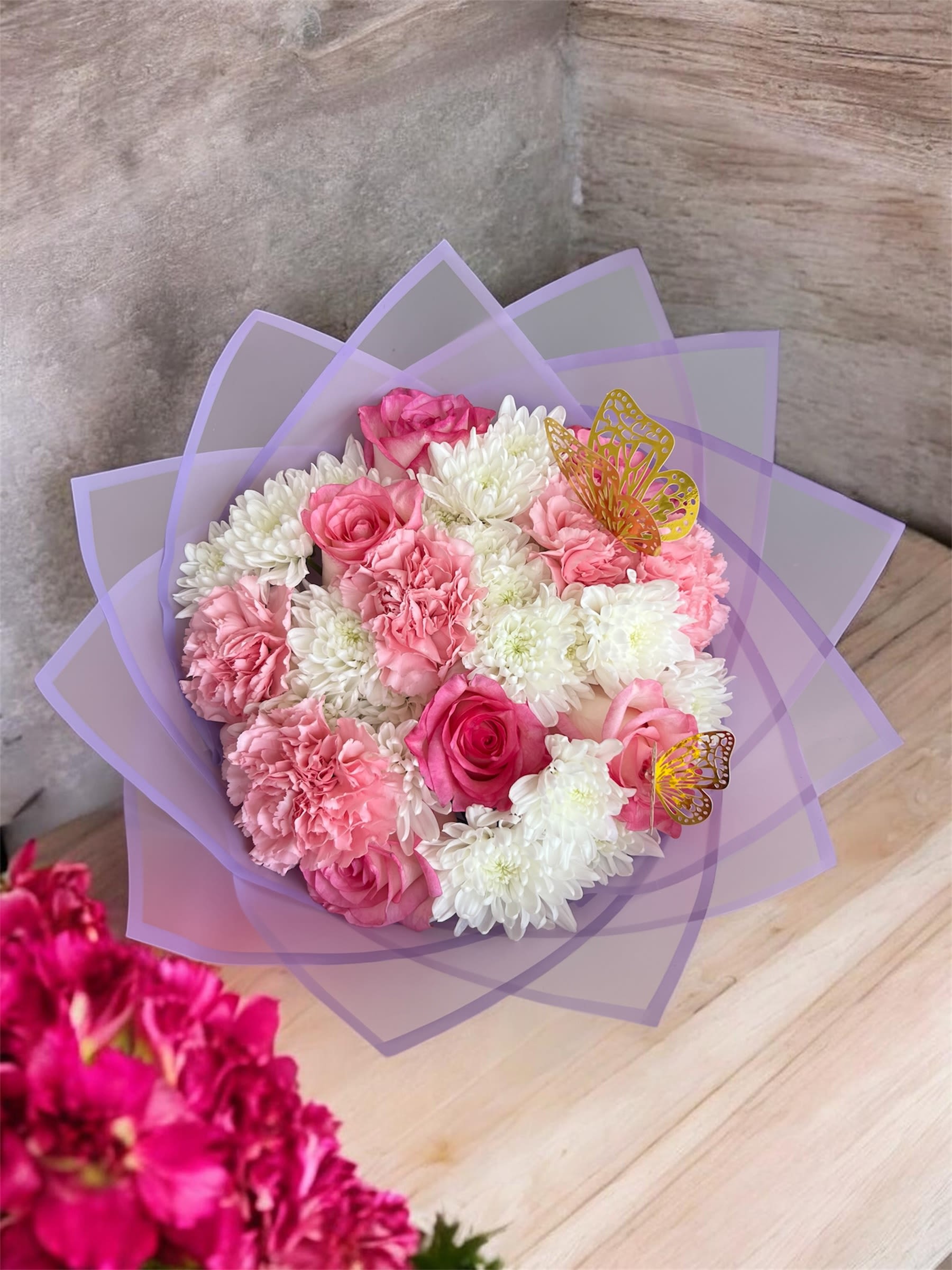 Pink and white bouquet wrapped in lavender paper