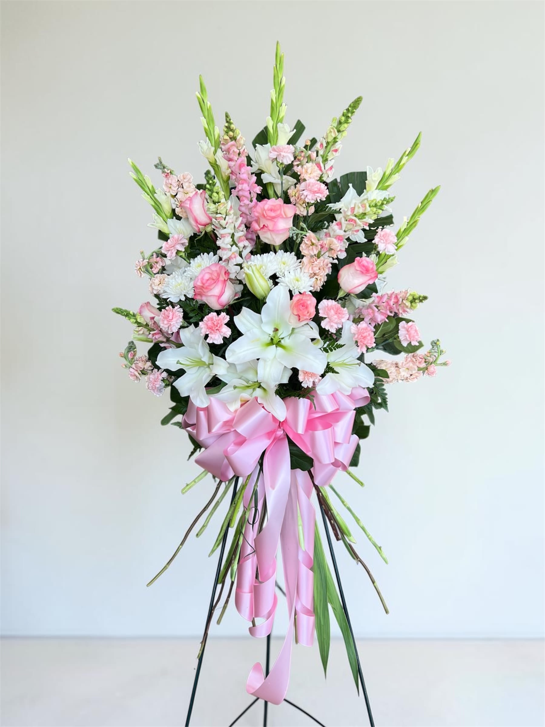 Last Goodbye Easel (pink) - A tall, graceful standing spray in soft pink and white that offers a gentle farewell - perfect as a sympathy arrangement or for a memorial service. The Last Goodbye Easel (pink) is designed to express comfort and remembrance, the kind of arrangement that lets the person you're honoring feel tenderly seen during a solemn moment.