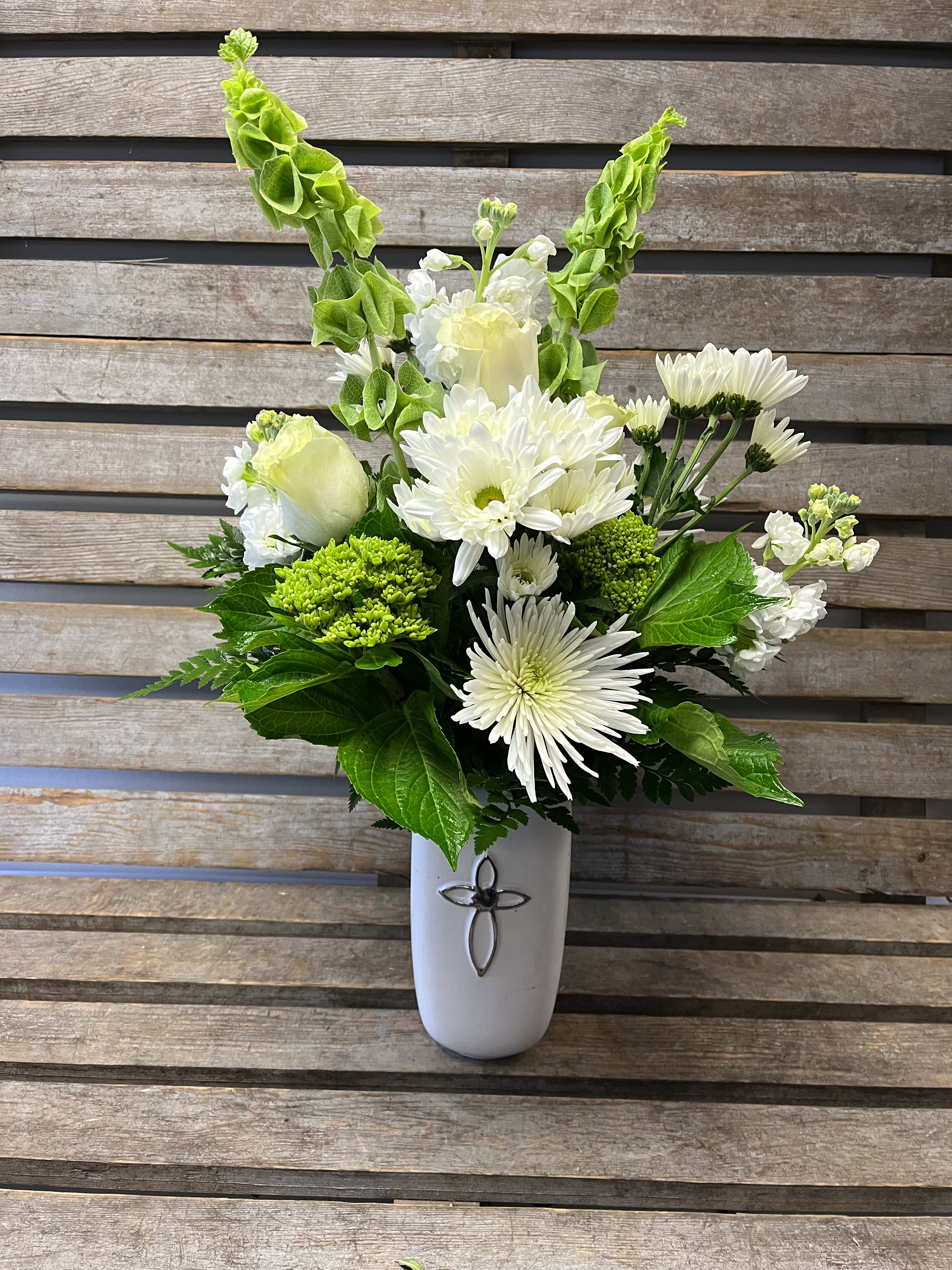 Eternal Cross arrangement  - White ceramic vase with a silver embossed cross. Filled with designers choice of white and green seasonal flowers. Perfect for the service or the home.