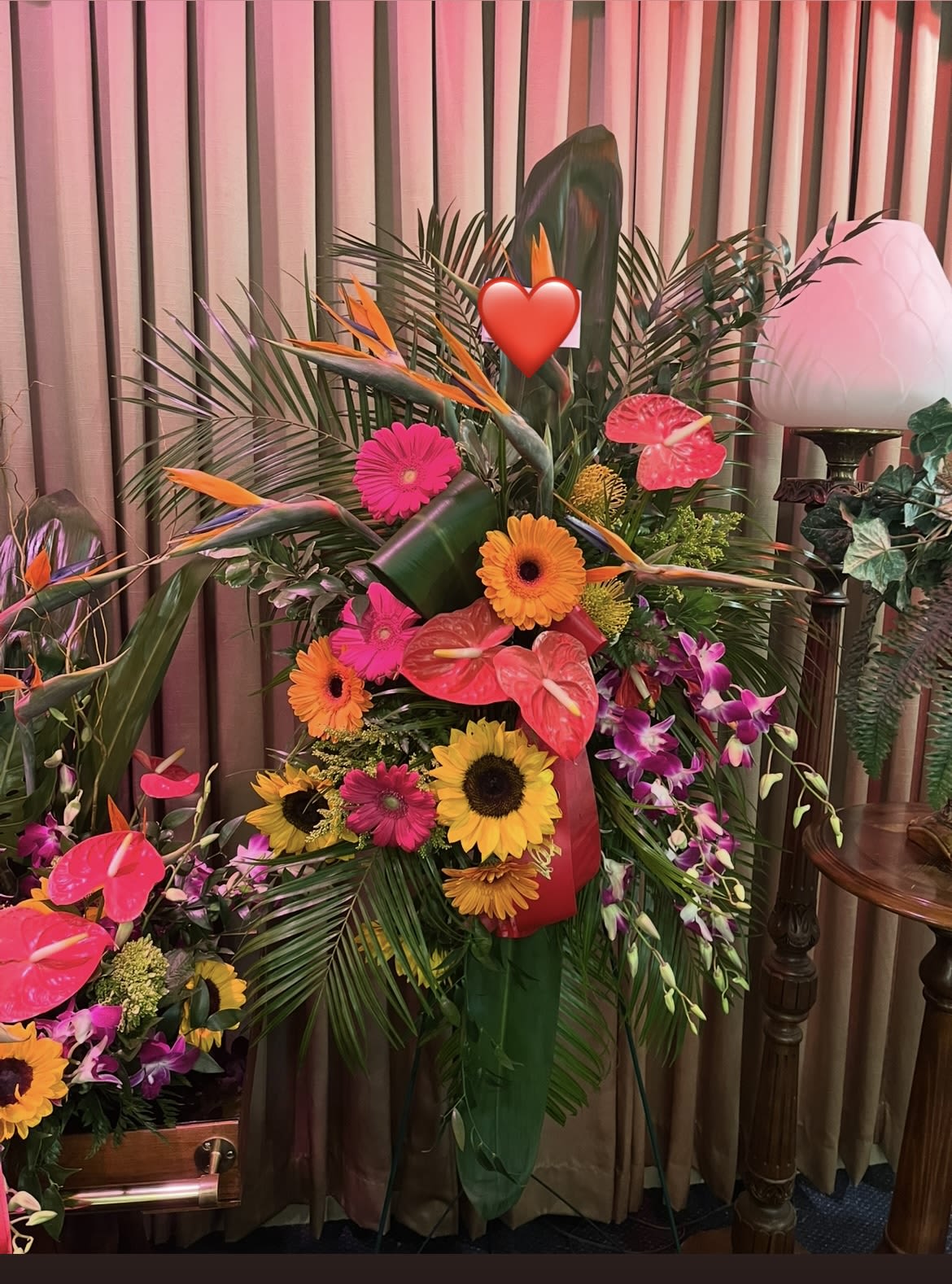 Tropical floral arrangement with sunflowers, gerbera daisies, and pink anthuriums