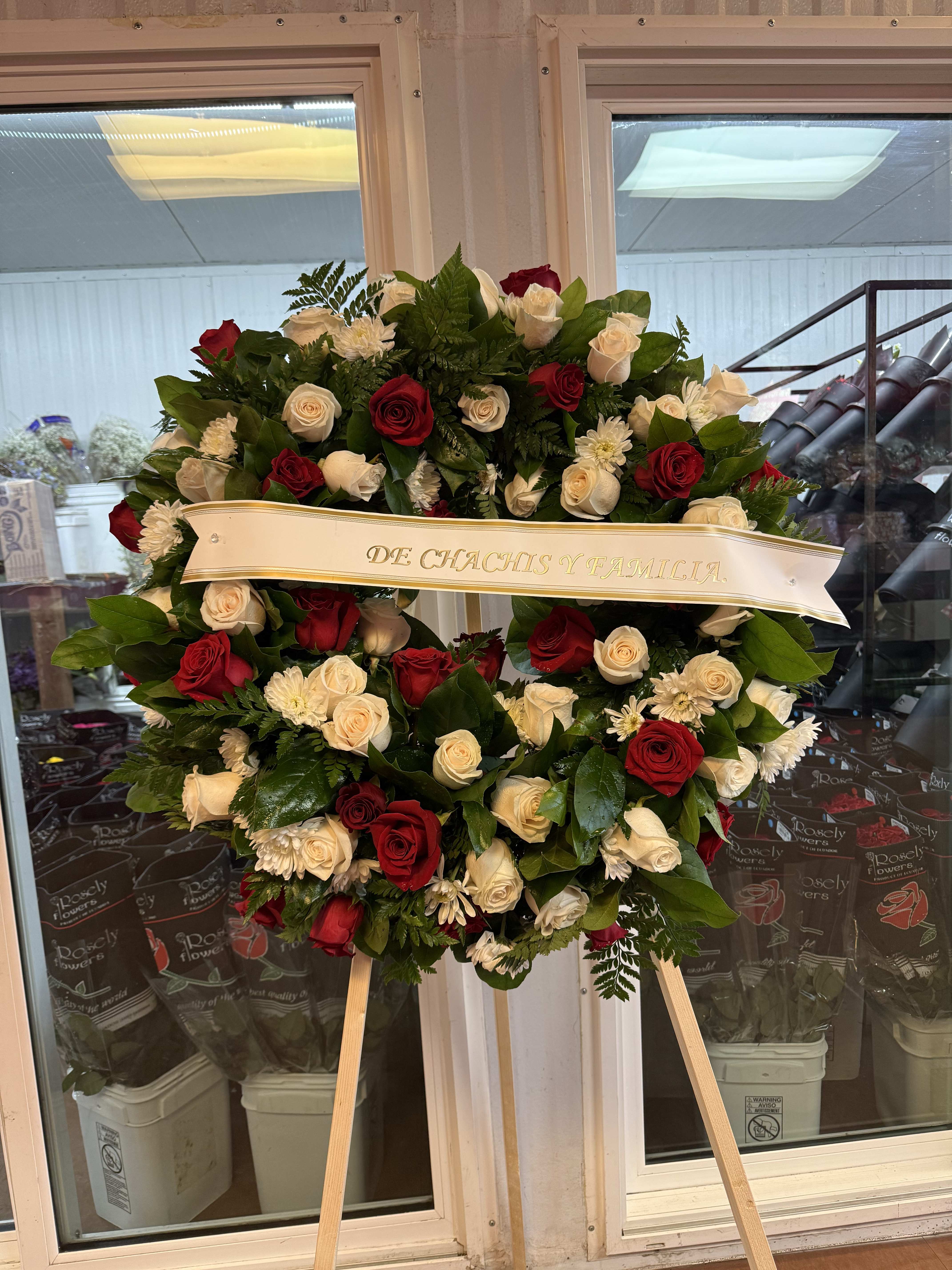 Heart-shaped wreath of red and white roses on a stand