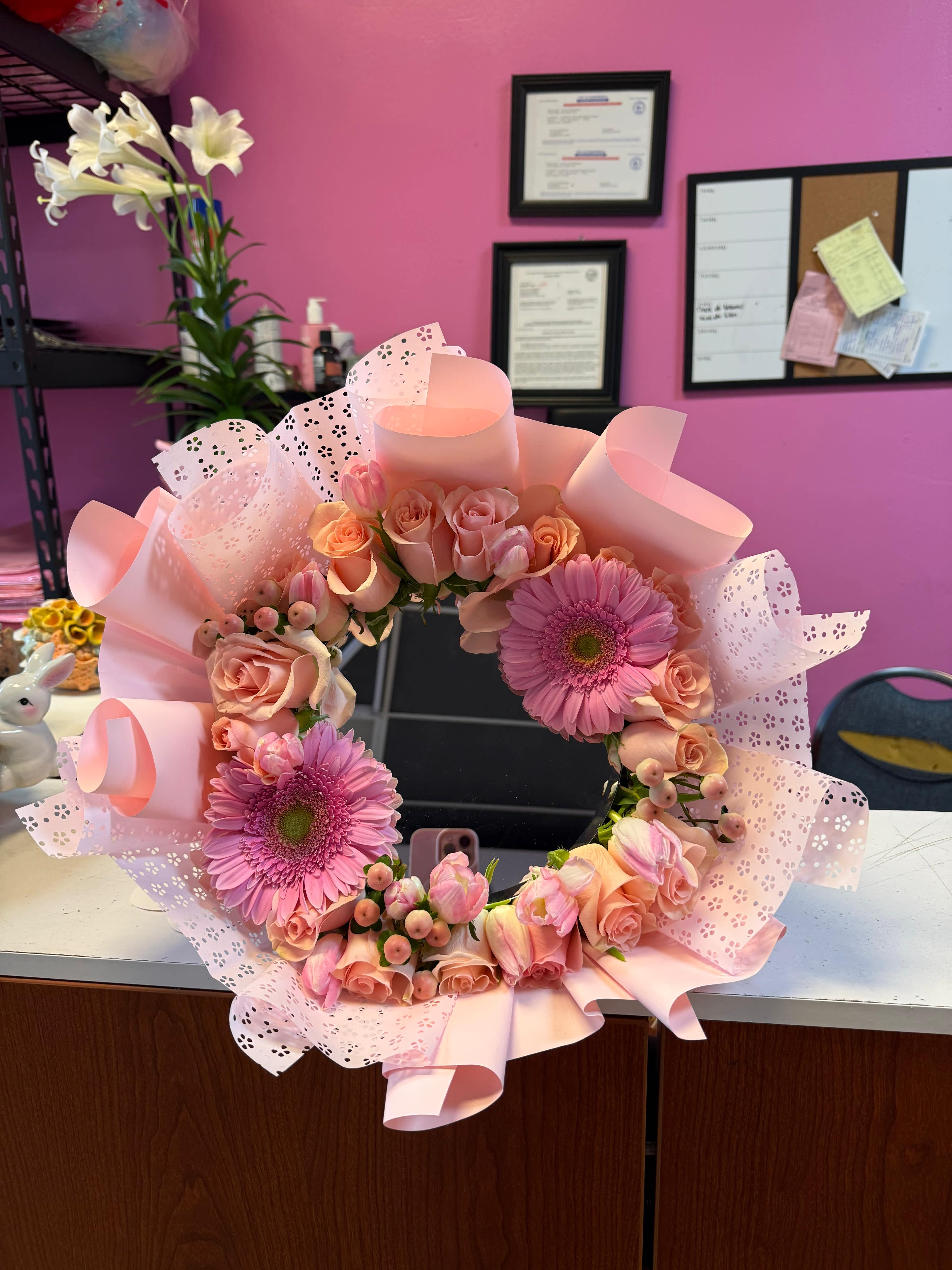 Pink floral wreath with roses and gerbera daisies wrapped in pastel paper