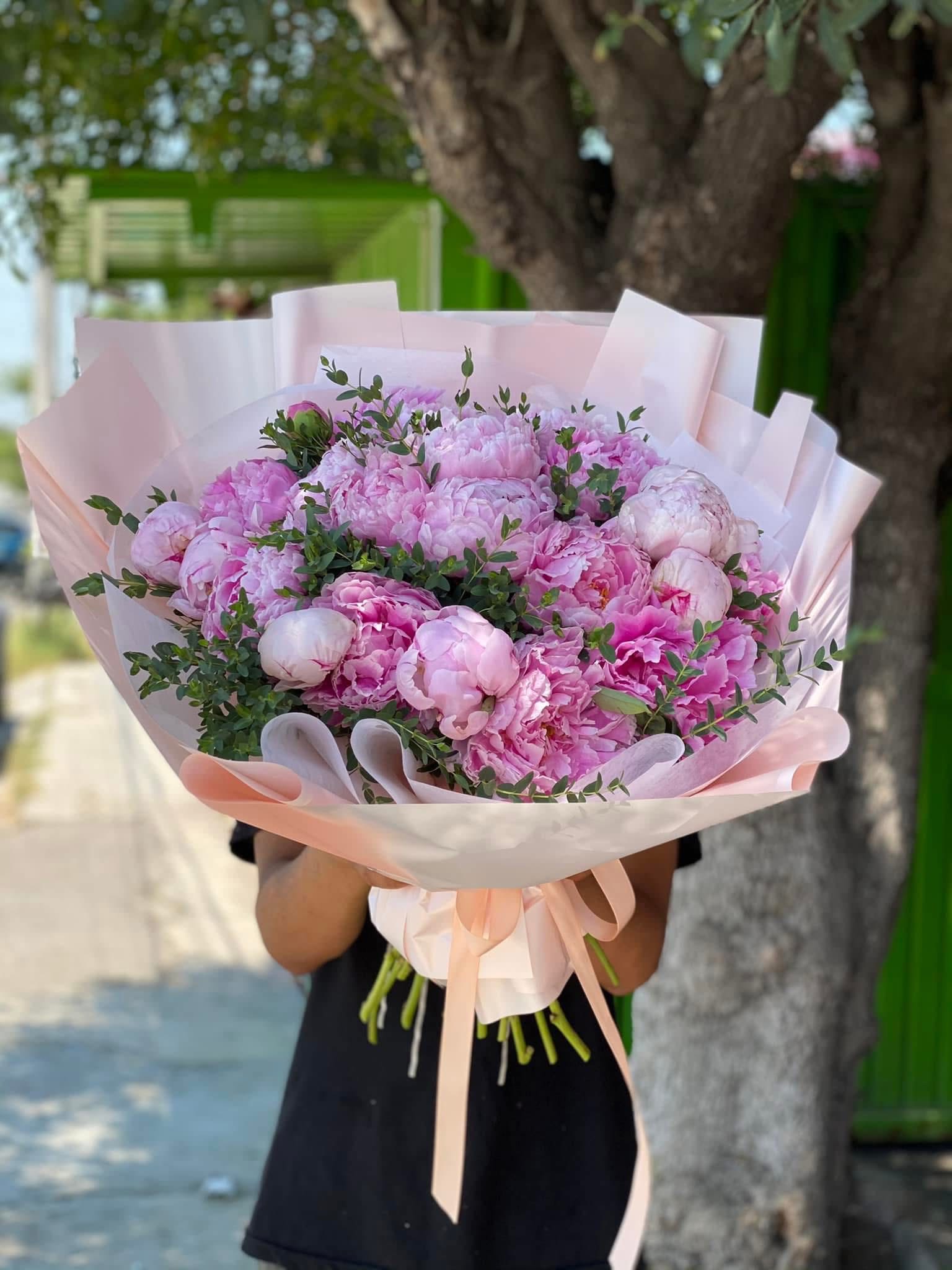 Large bouquet of pink peonies wrapped in pale pink paper