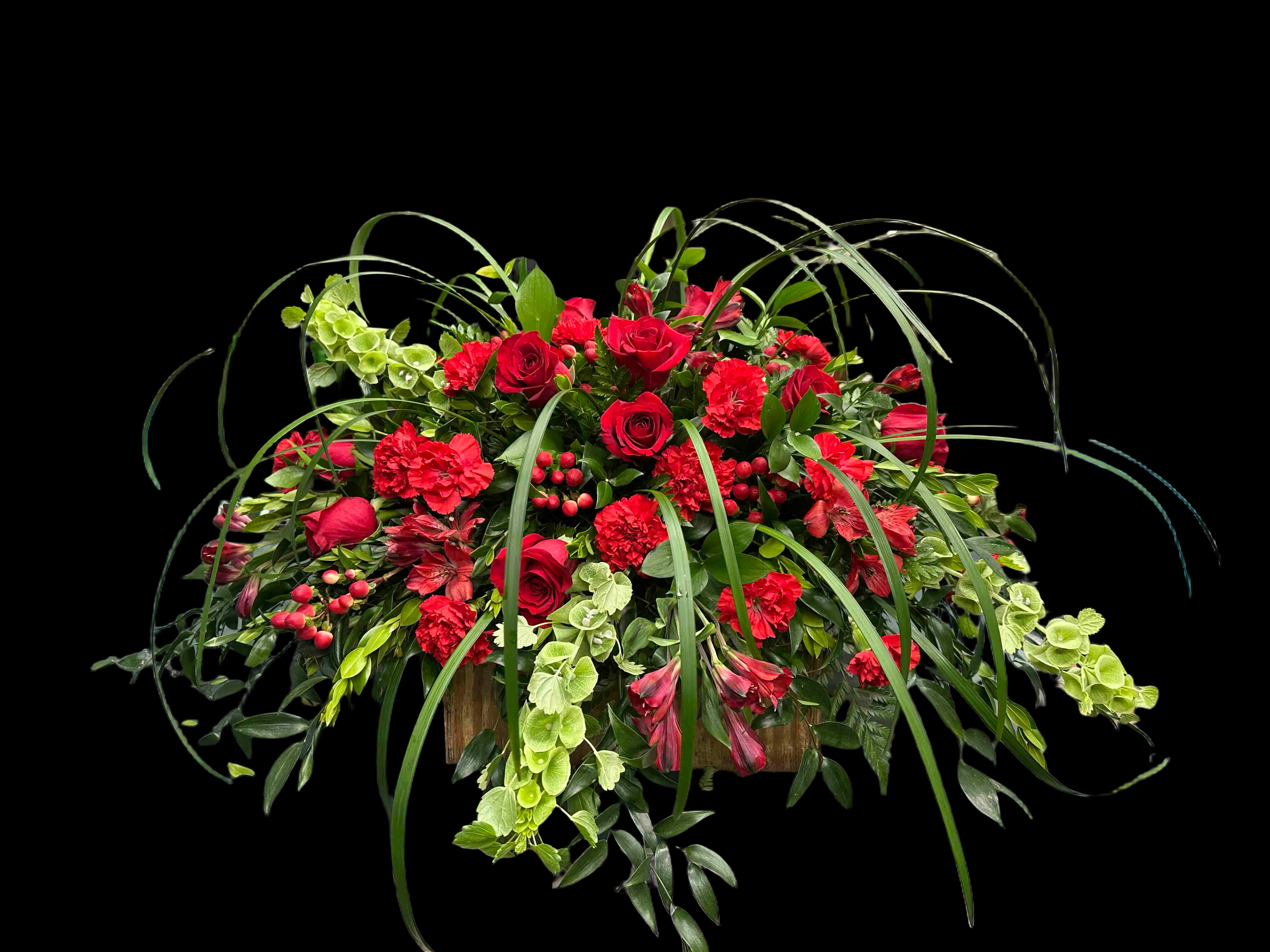 Red Radiance Casket Spray - Casket spray of vivid red roses and carnations with trailing greenery 