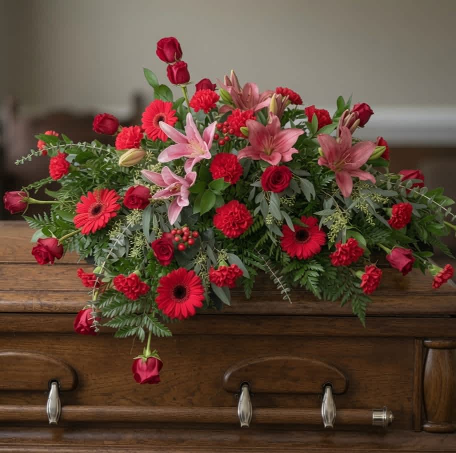 Red and pink floral arrangement with lilies, roses, and gerbera daisies