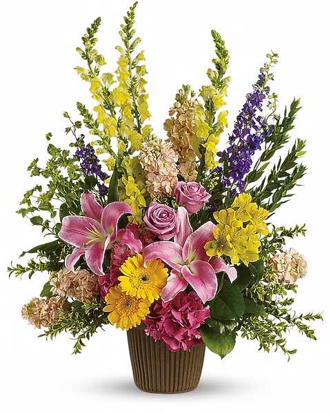 Mixed bouquet with pink lilies, roses, and yellow flowers in a brown vase