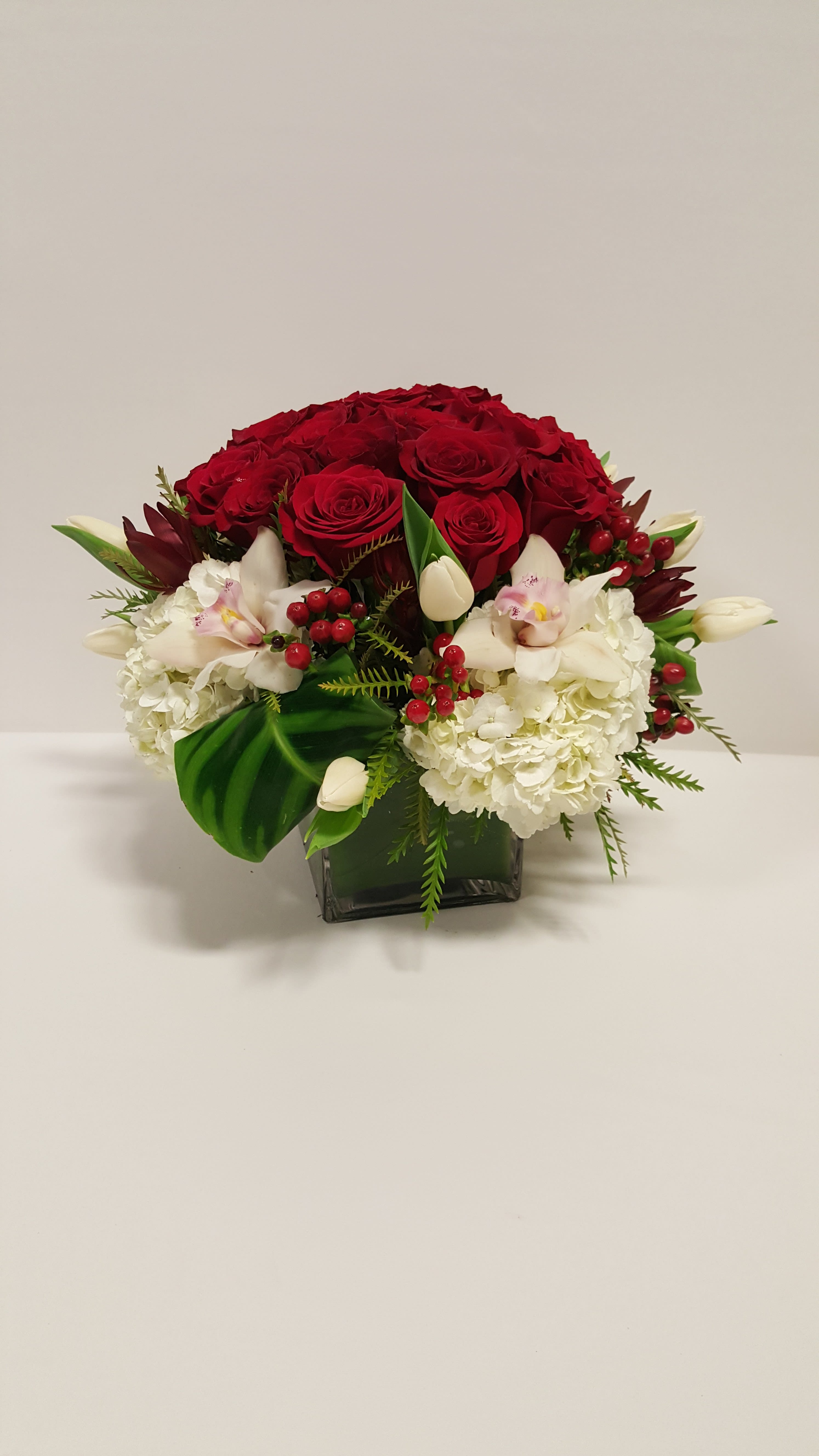 Head Over Heels - 6X6 square vase with some beautiful red roses and a mix of other beautiful flowers