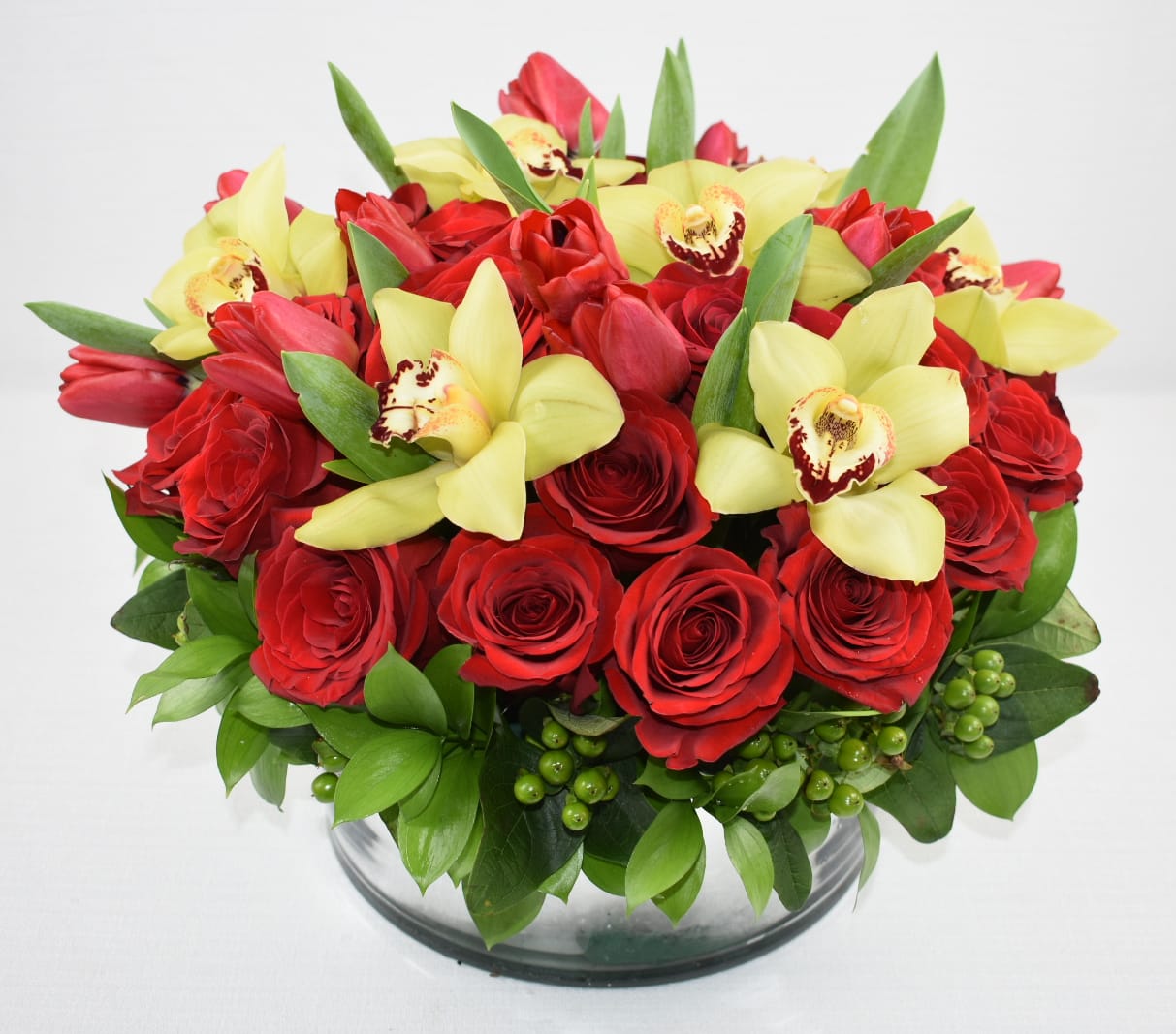Magnificent  - Lovely floral arrangement in a round low vase  with 3 dozen Ecuadorian red roses, green cymbidium orchids and red tulips  Perfect for any occasion 