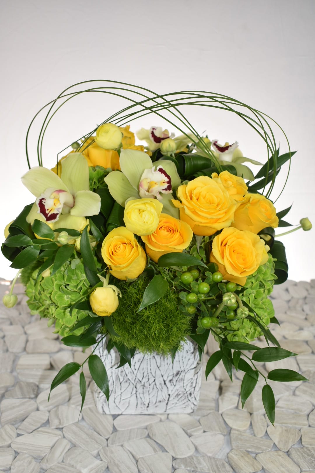 summer meadow  - This arrangement comes in a white rustic ceramic vase  With green hydrangeas, yellow roses, yellow ranunculus, green coffee bean, green cymbidium orchids, dianthus, folded aspidistra, and lily grass to finish the final design some italian roscus   Perfect for  birthday flowers anniversary flower  just because flowers  congratulations flowers  Get well flowers  Christmas flowers Valentines Day flowers Mother's Day flowers