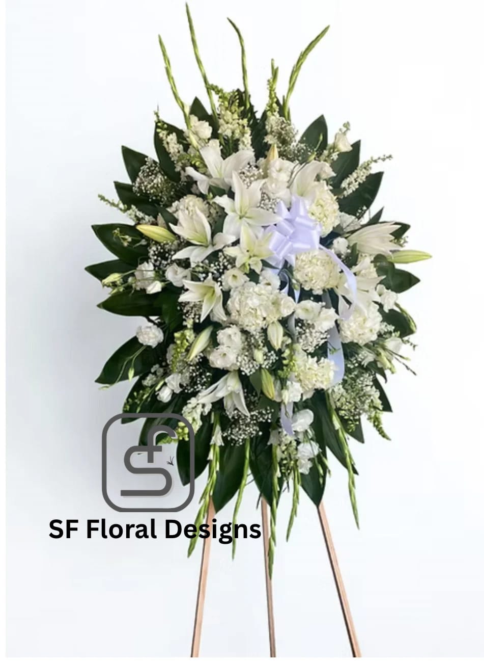Tall white standing spray with lilies and other white flowers on a wooden easel