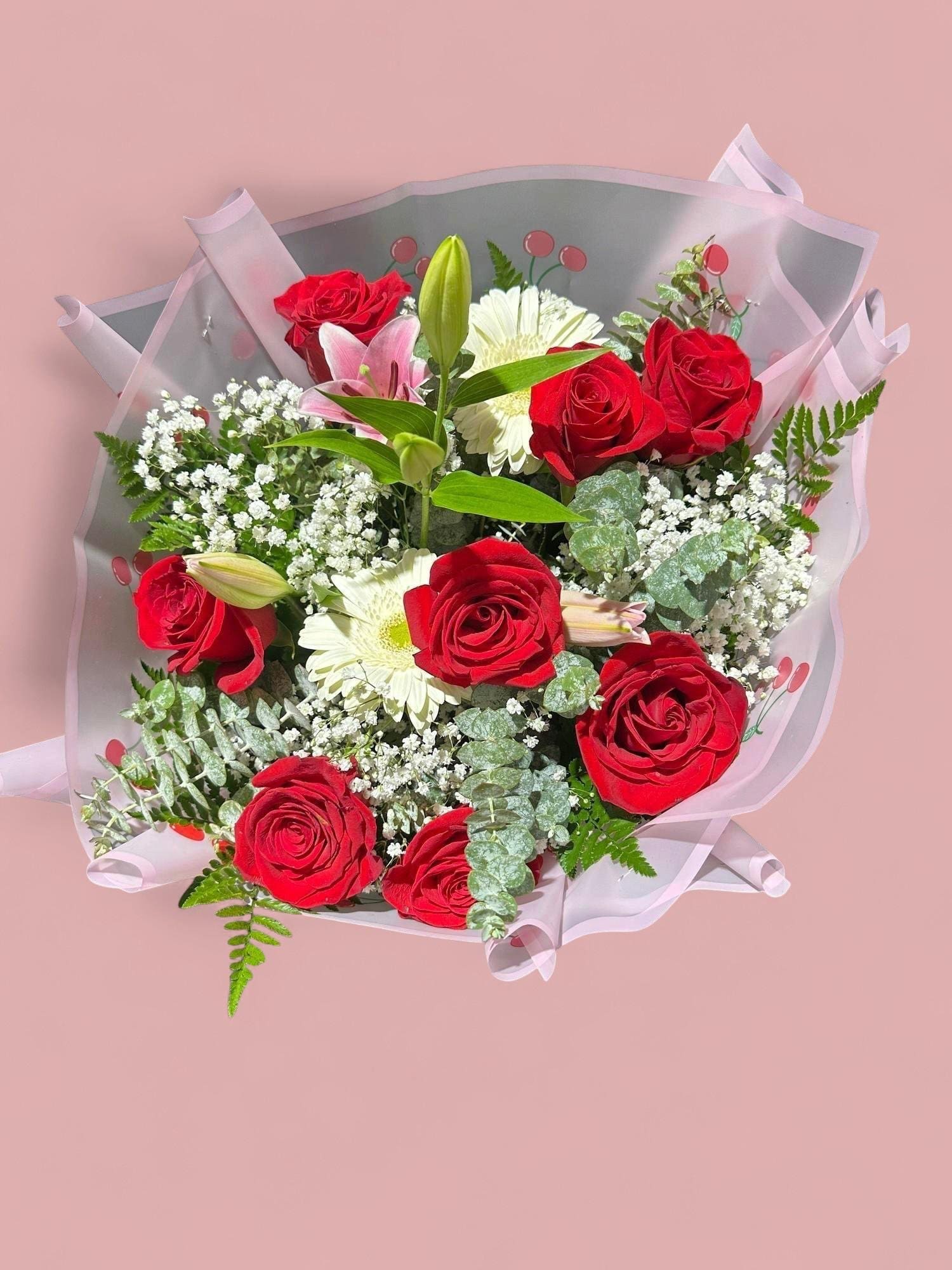 Bouquet of red roses and white flowers wrapped in pink paper