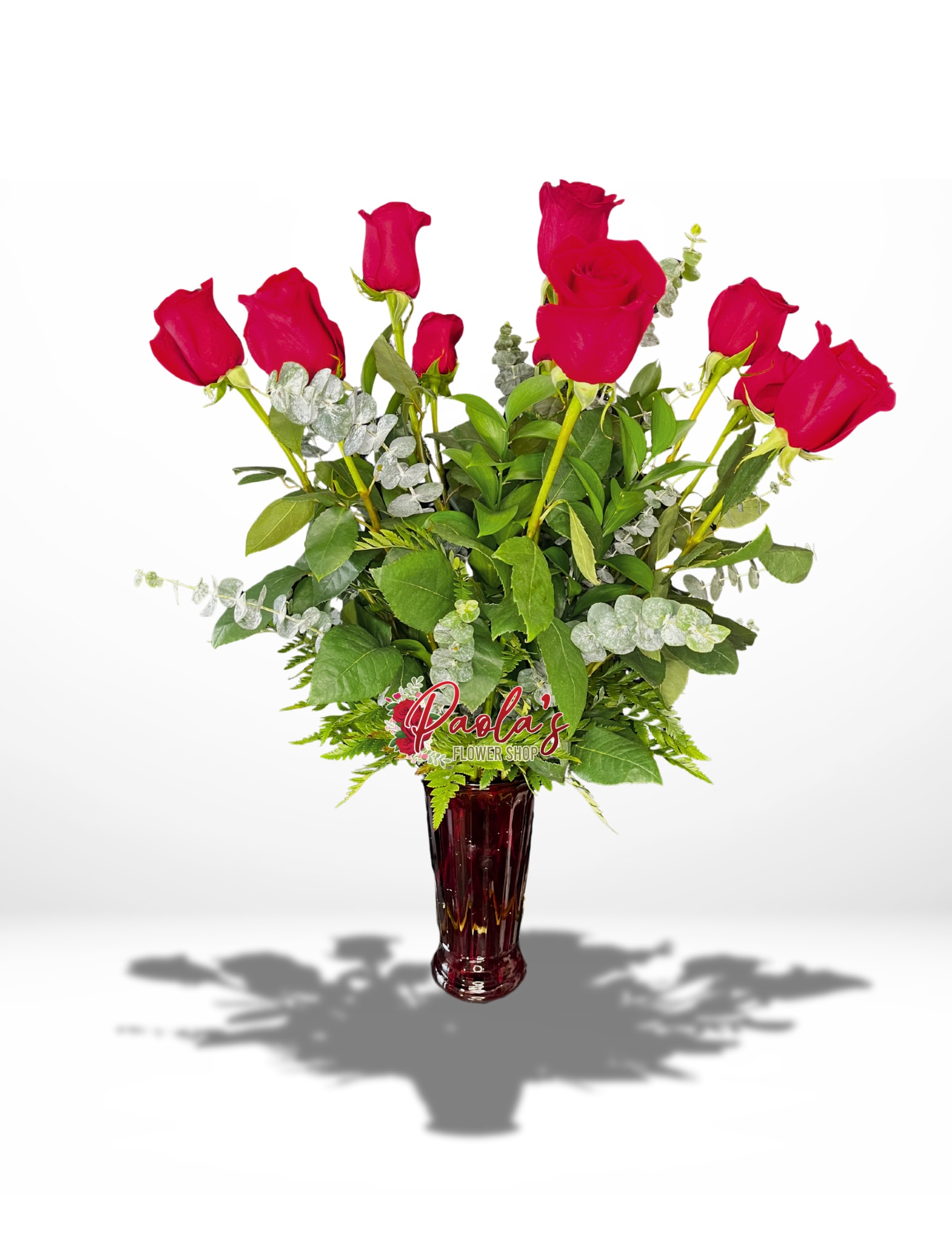 Red roses arranged in a tall burgundy vase