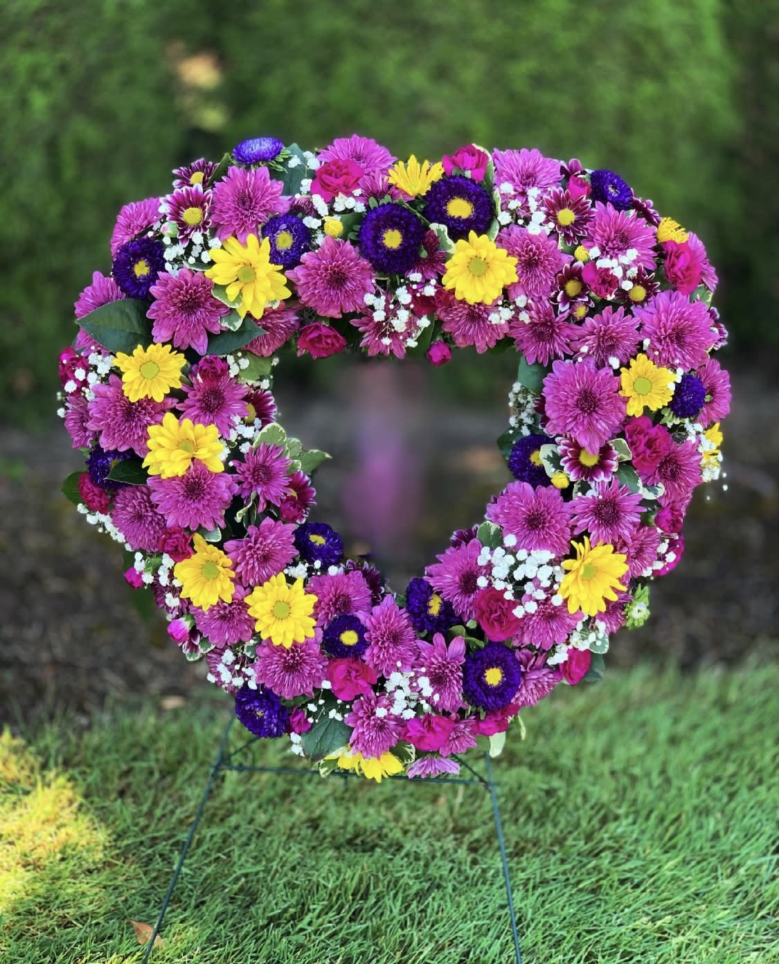 Heart-shaped floral wreath with pink, yellow, and purple flowers